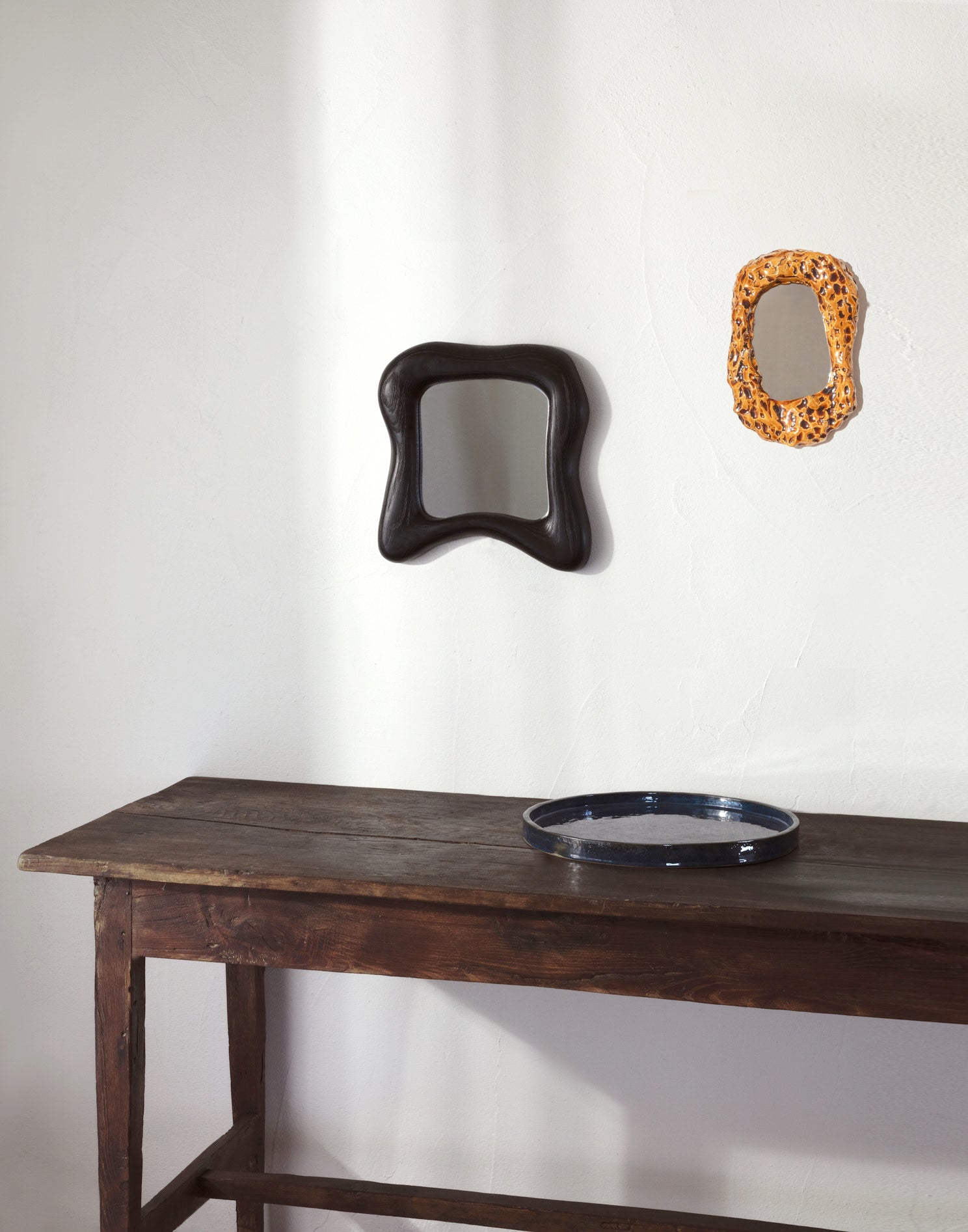 Minho Mirror — back view on wooden table against white wall
