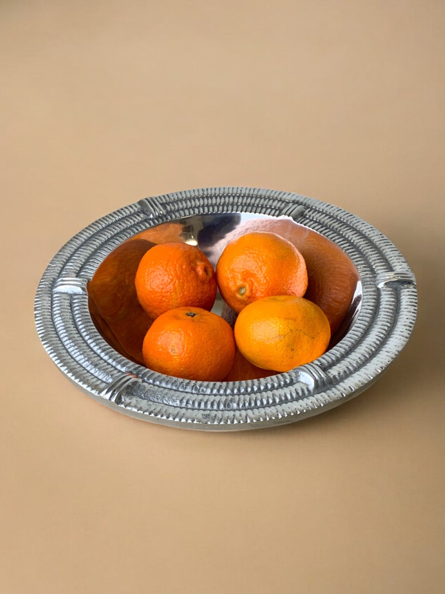 Ridged Circular tray, solid aluminium, Spain, 1980's — side angle with oranges inside
