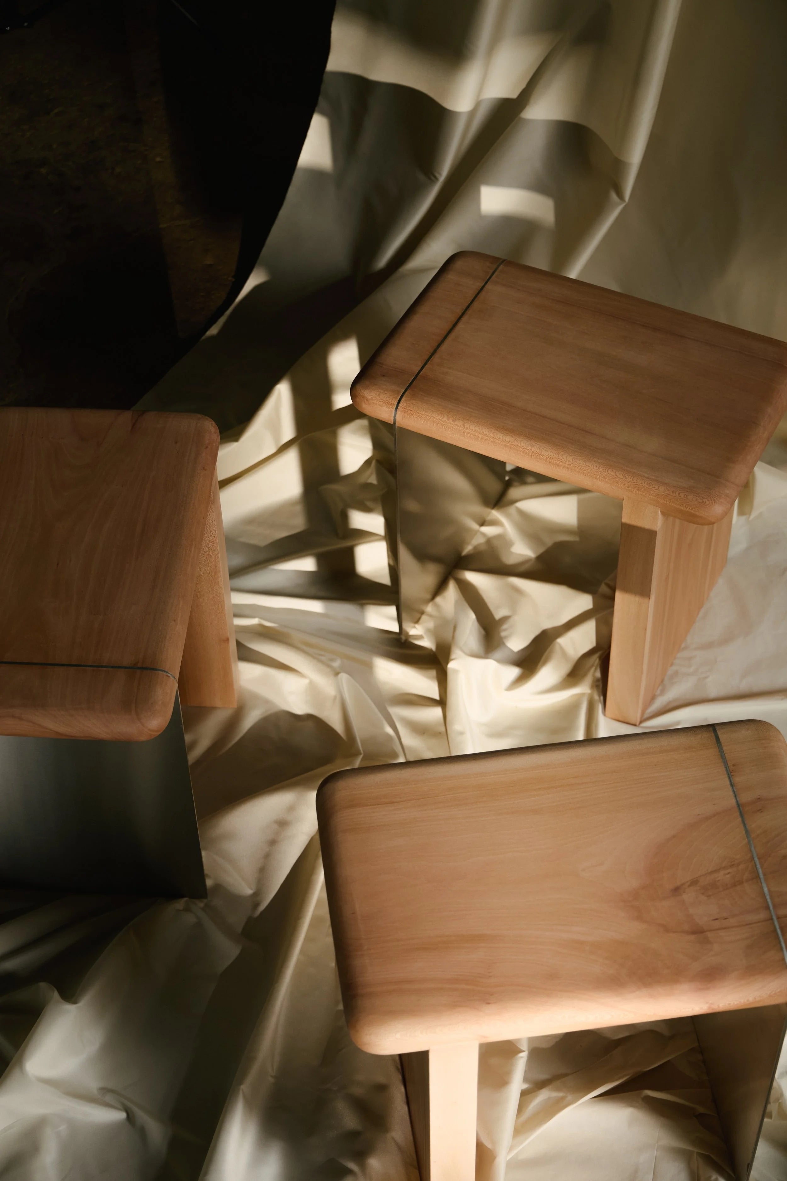 The Ferro Side Table — angled view on draped fabric background