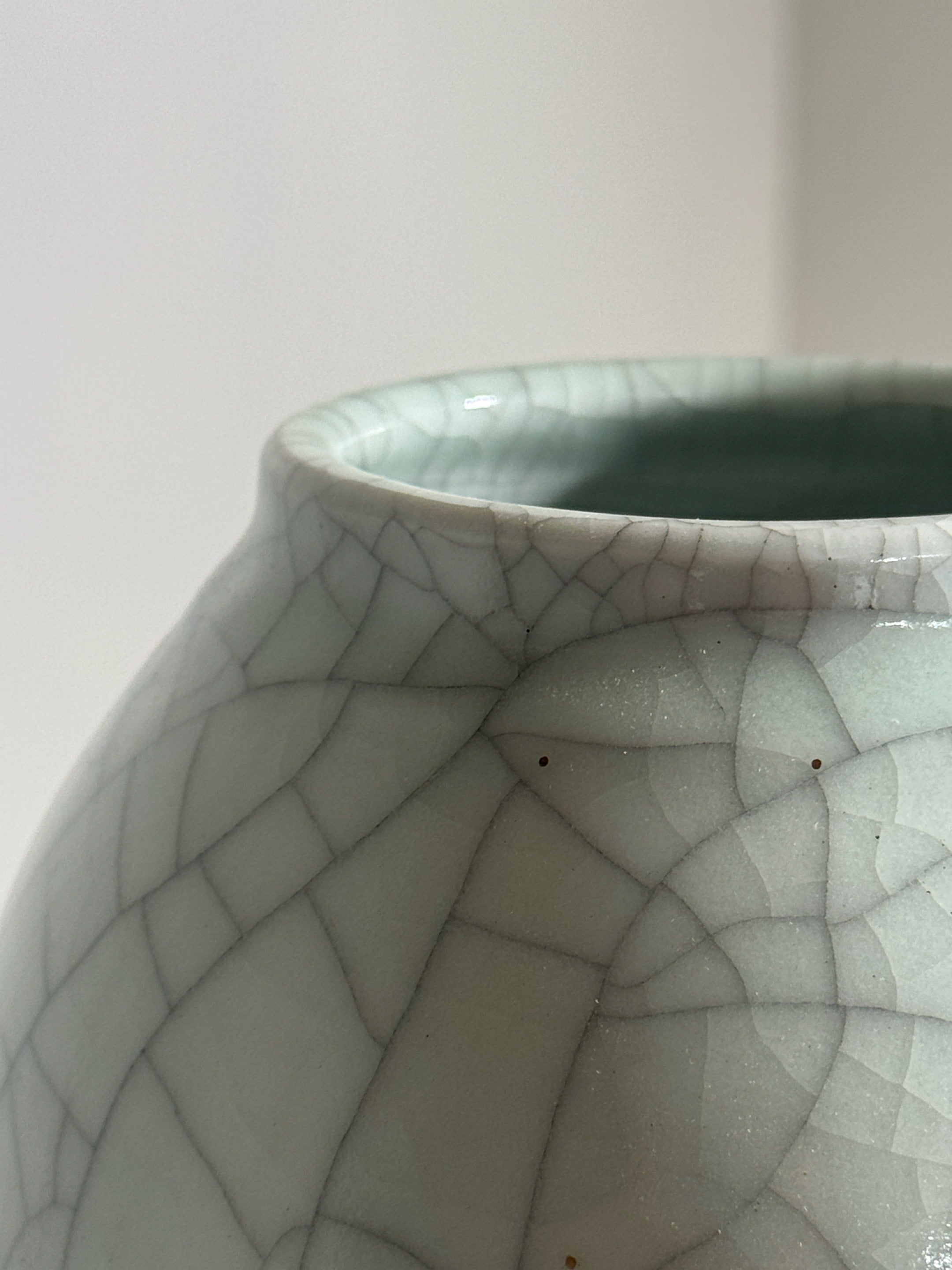 Close-up detail of crackled ceramic glaze on white vase interior