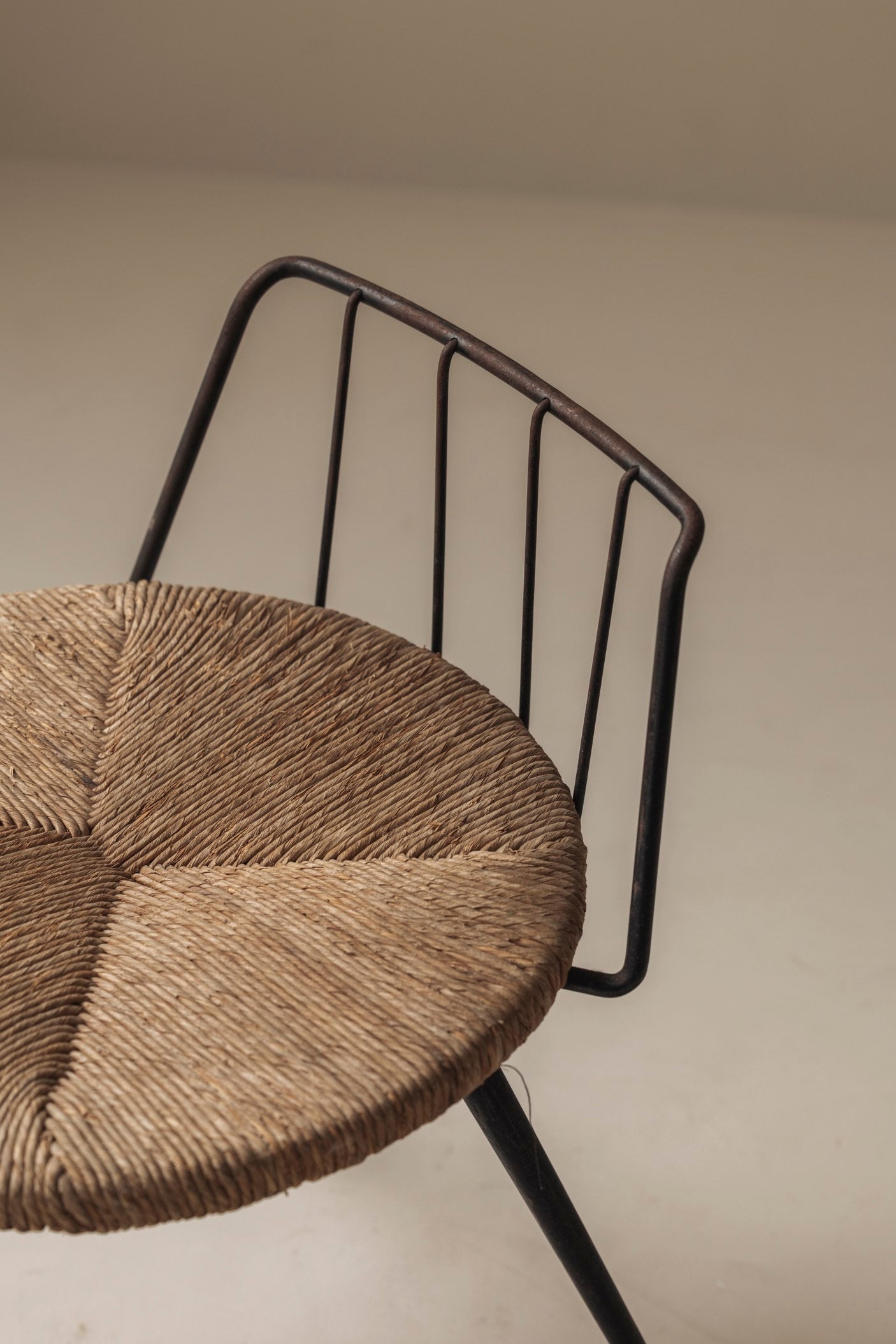 Rare French tripod stool in metal and rush, dating from the 1950s — side angle
