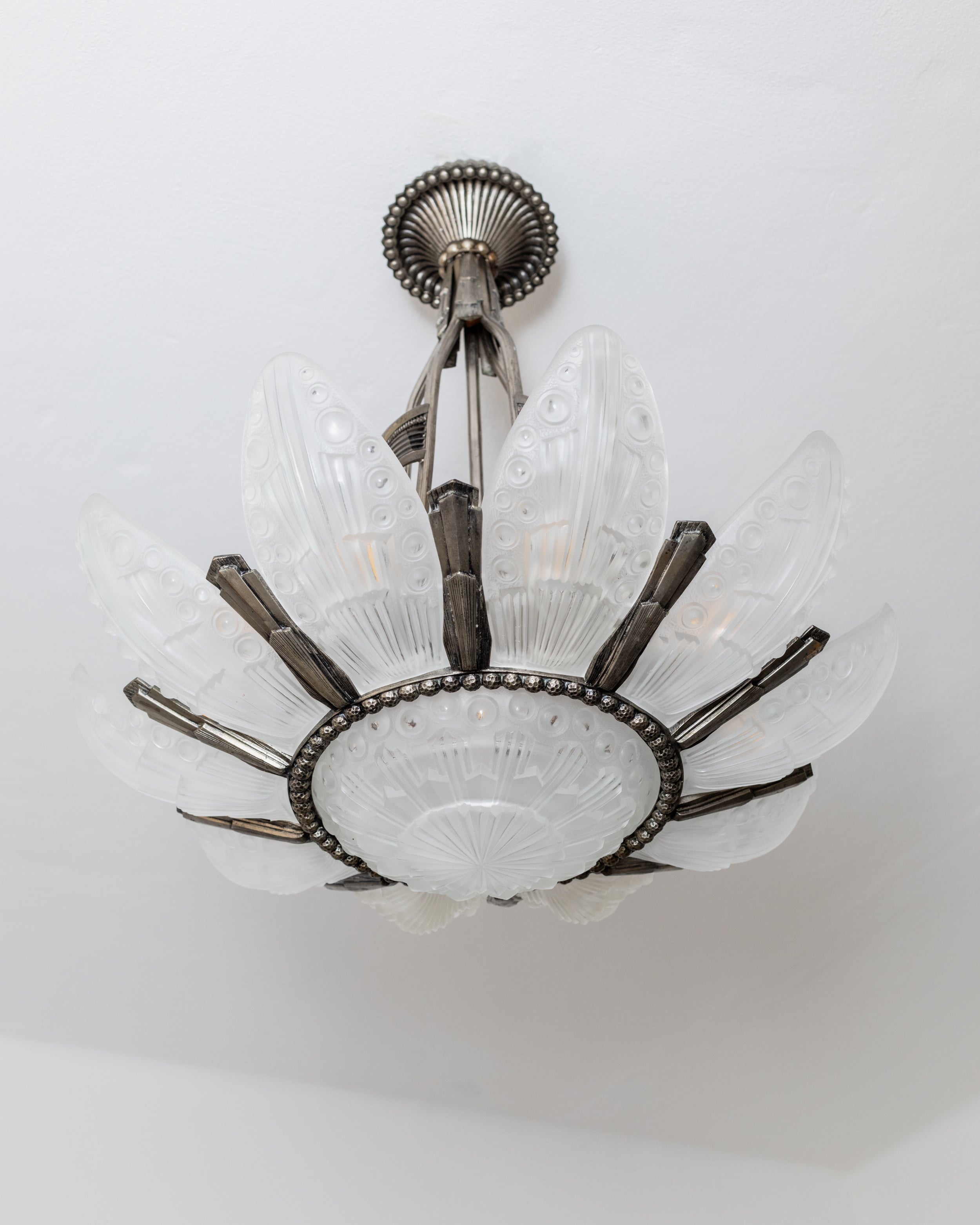 Art Deco chandelier detail showing frosted glass petals and metal frame