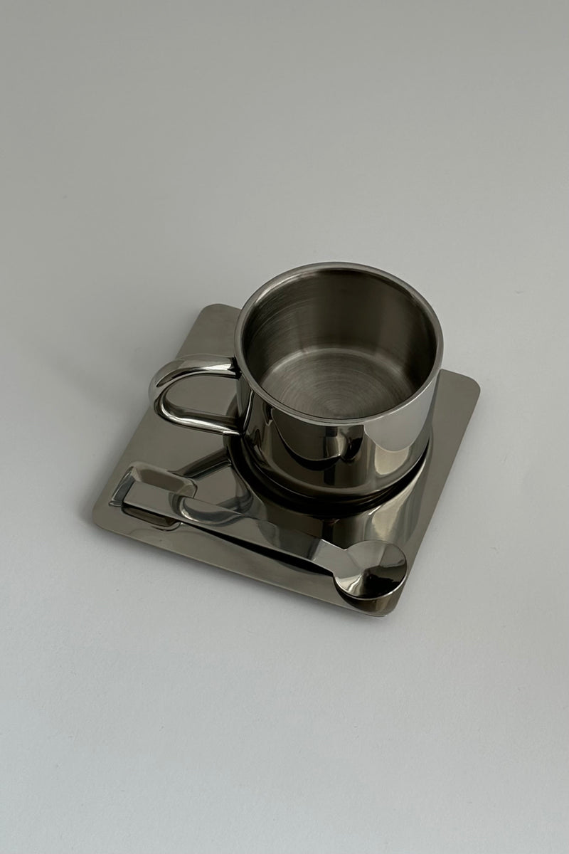'HEDONISM' stainless steel cup with saucer — detail view