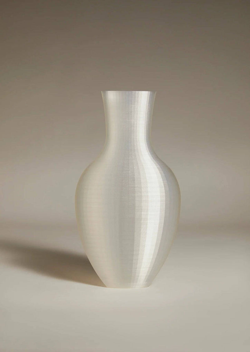 The Double Vessel - New Edition by Argot Studio is a tall, sculptural ceramic vase with a smooth, shiny surface. Against a neutral background, its contemporary design features a narrow neck and bulbous body, casting a soft shadow to the left.