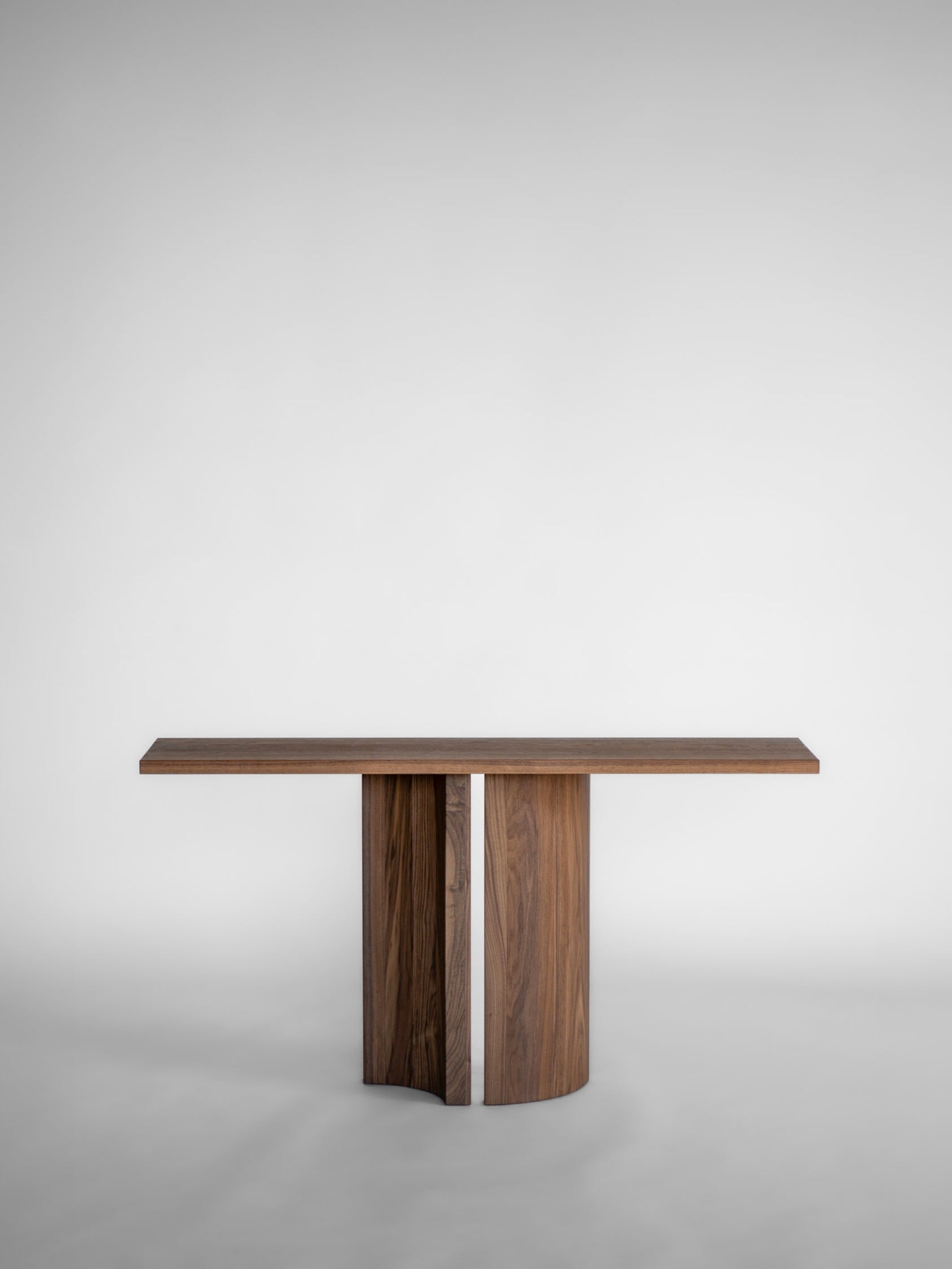 Aperta Console — front view of walnut table with unique base