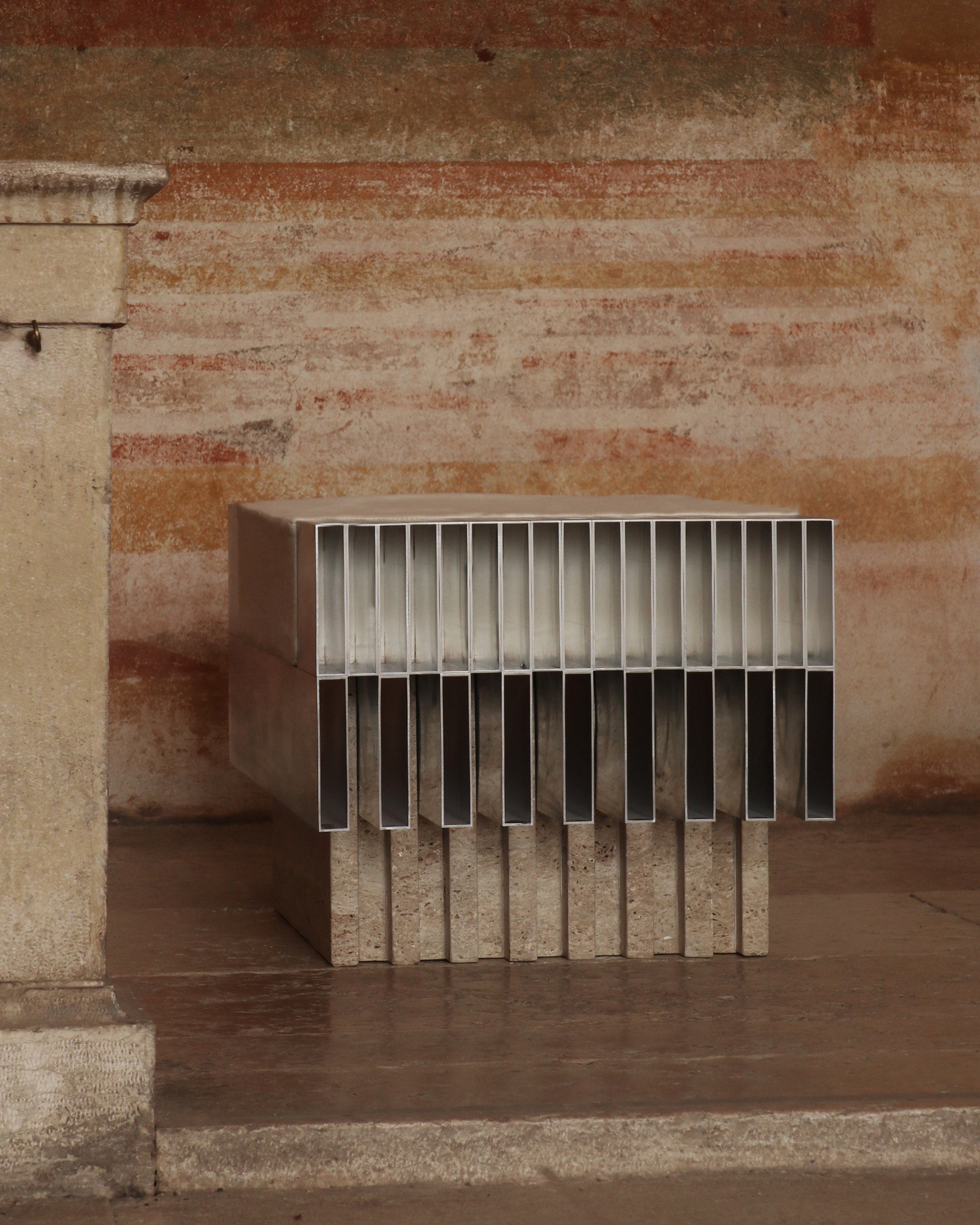 Modern steel ottoman with vertical slat design in rustic interior