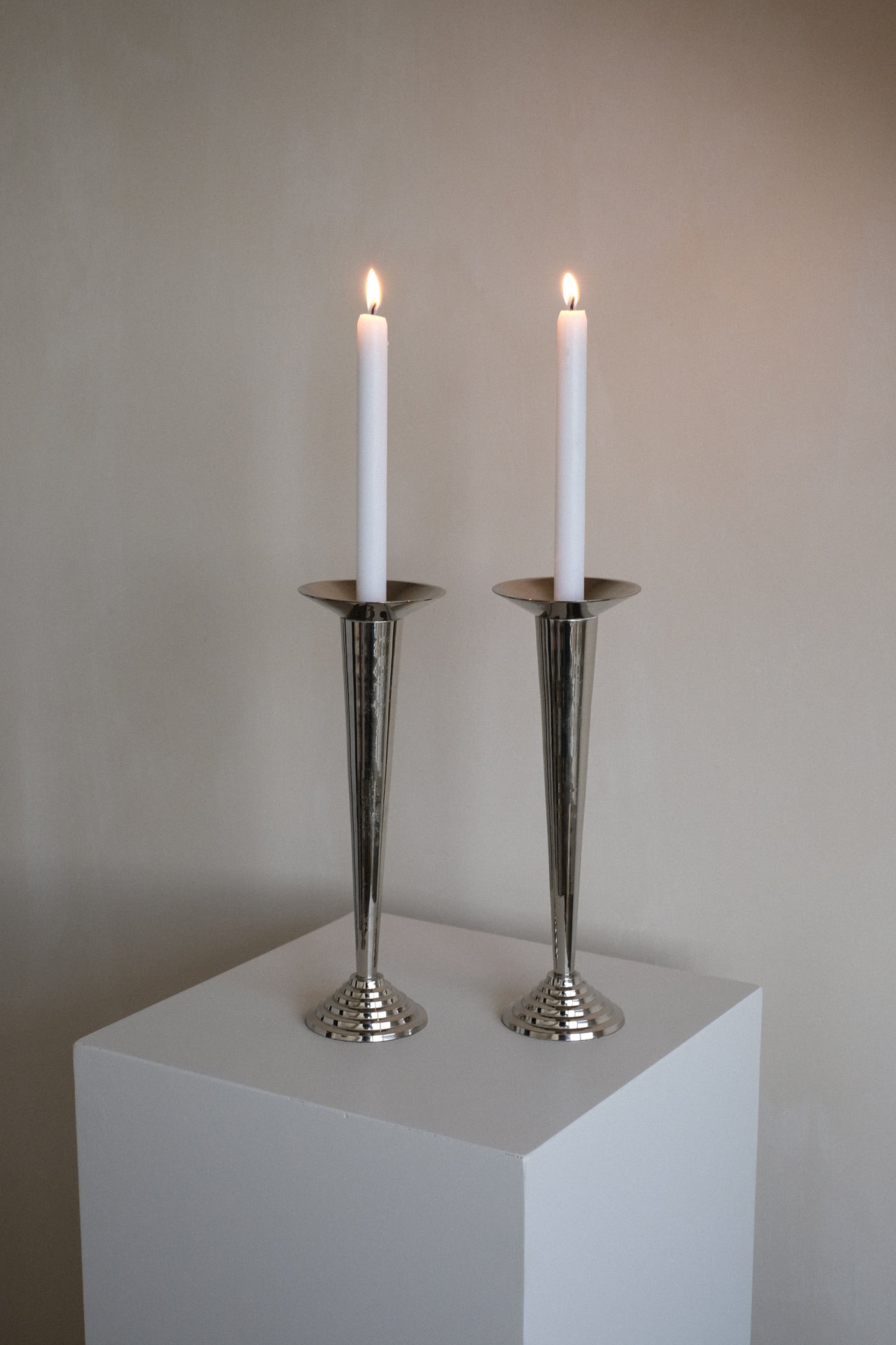 Art Deco Candle Holders — side angle on white pedestal with candles