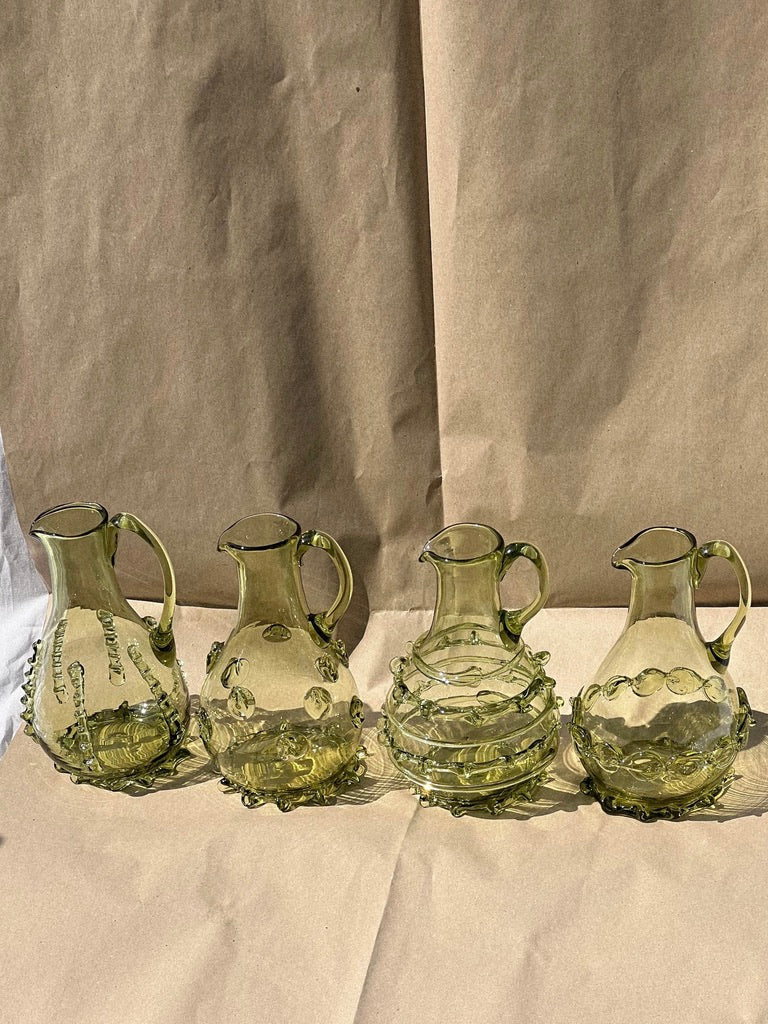 Contemporary Carafes in Glass with ornaments - Mouthblown Collection — arranged on textured paper backdrop