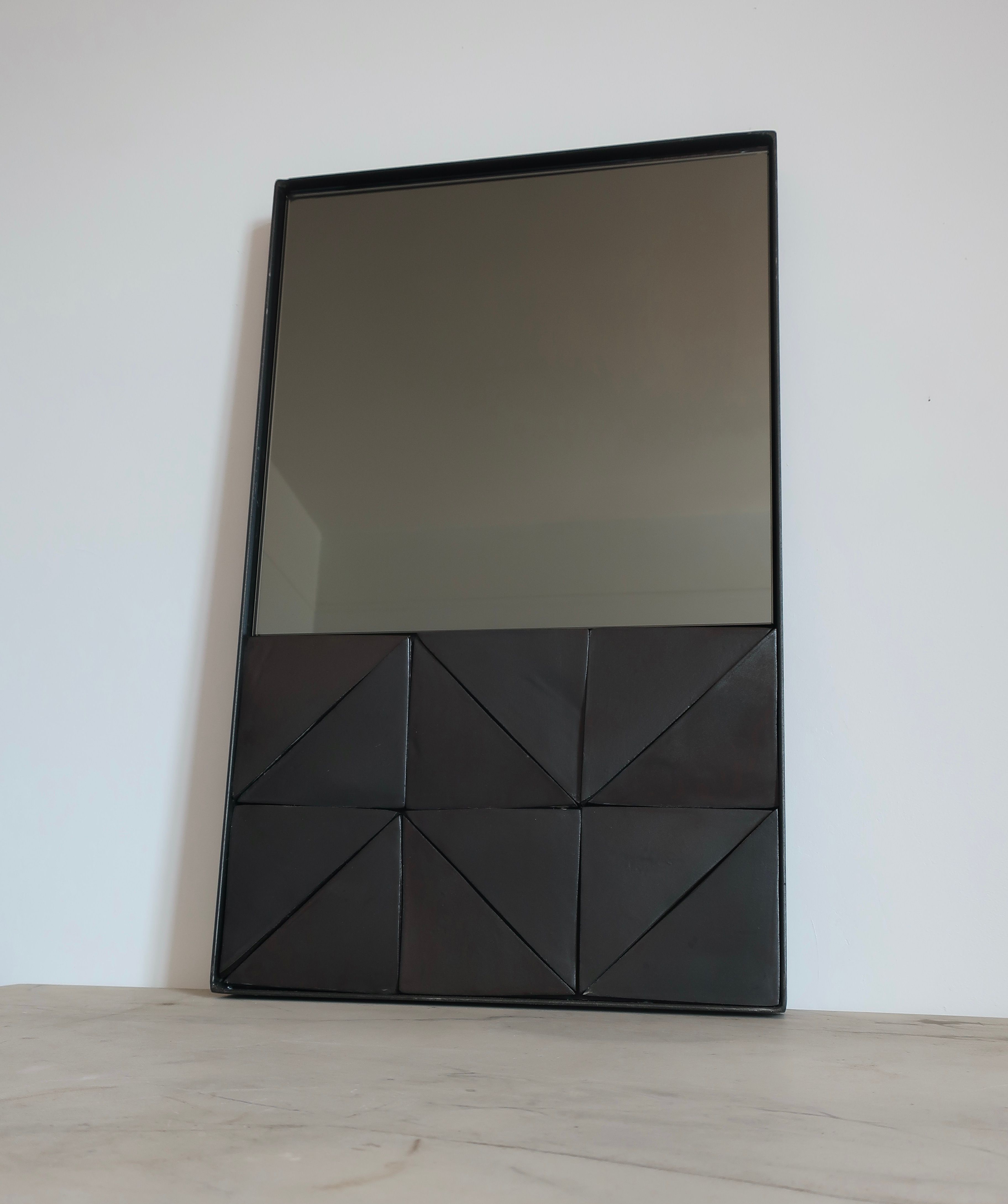 Alcoa mirror with geometric black triangular pattern base detail