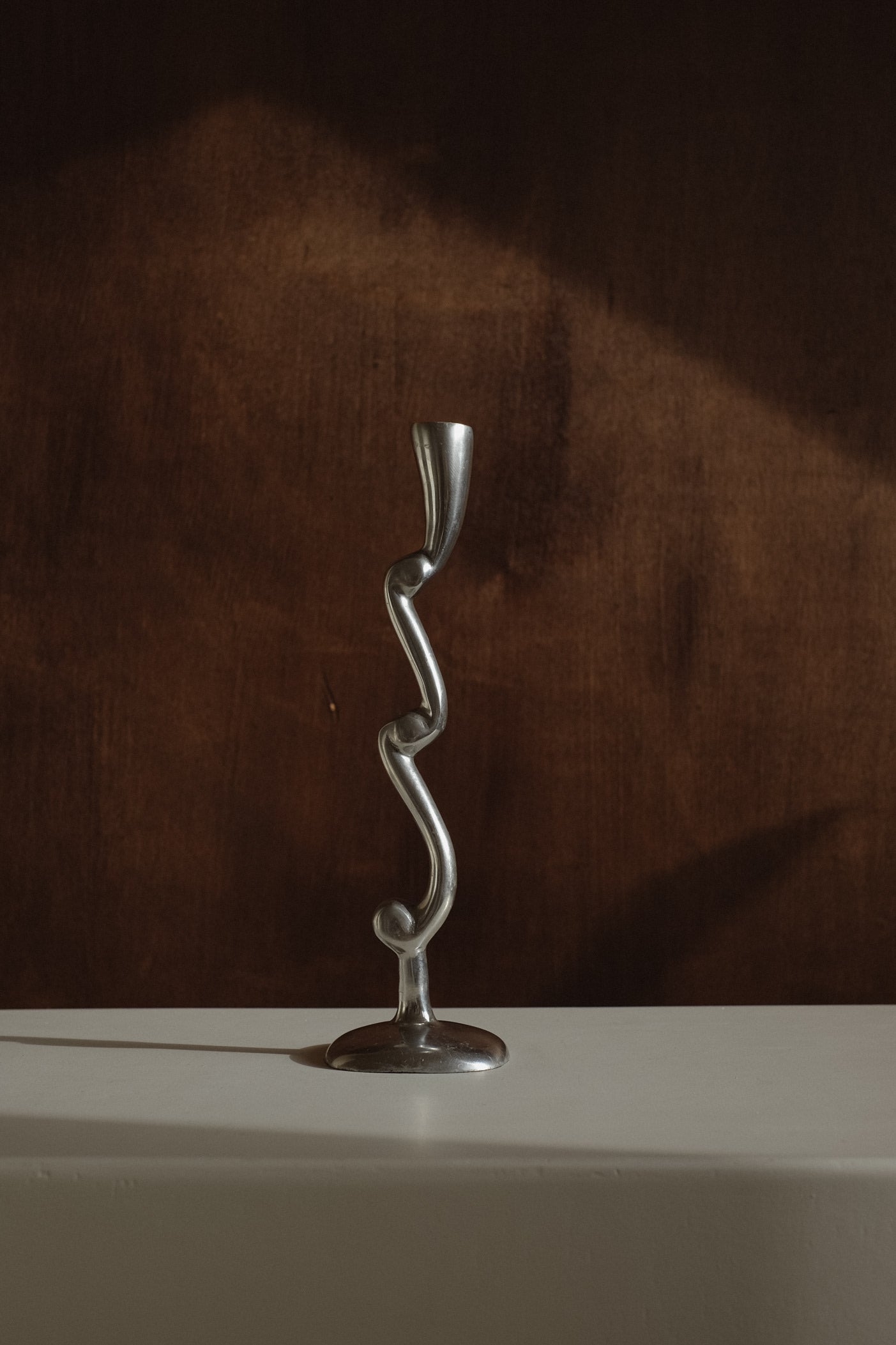 Curly Candle Holder — close-up of twisted metal design on white surface