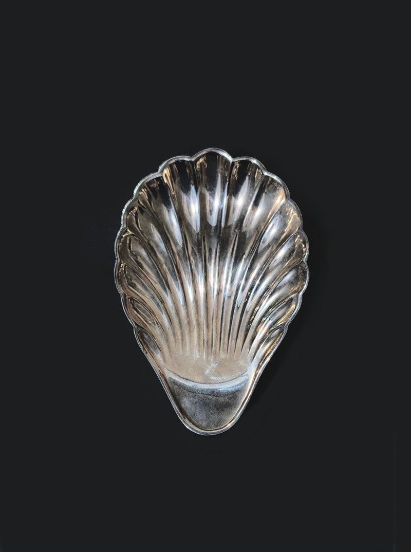 Silver-plated shell-shaped vide poche on dark background