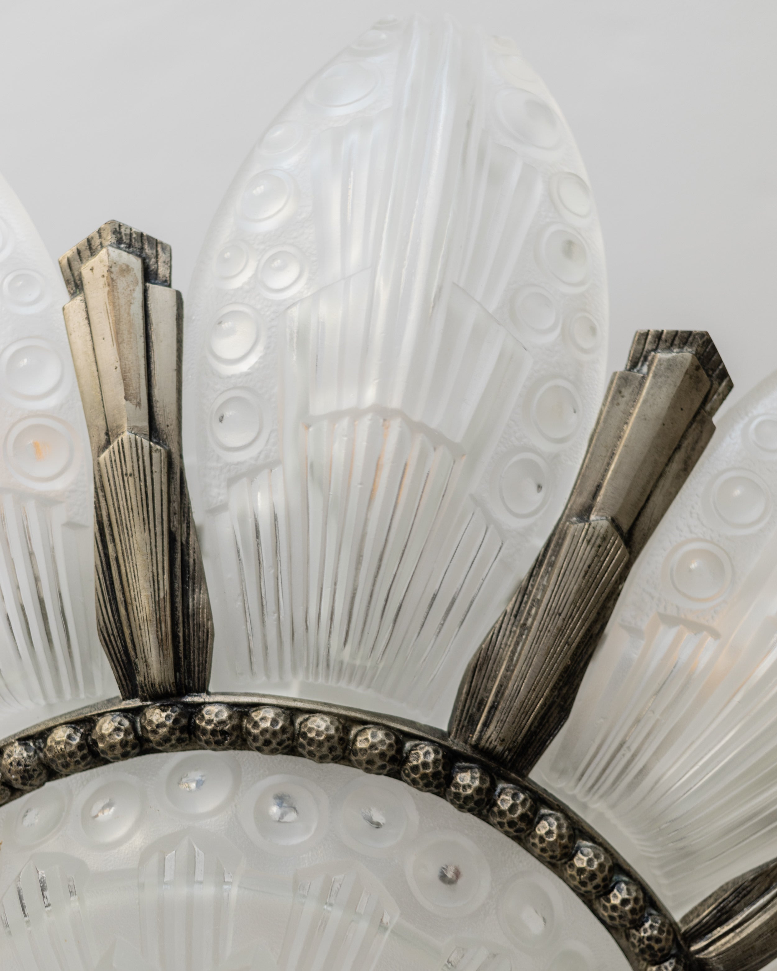 Close-up detail of Art Deco chandelier glass panels and metal frame