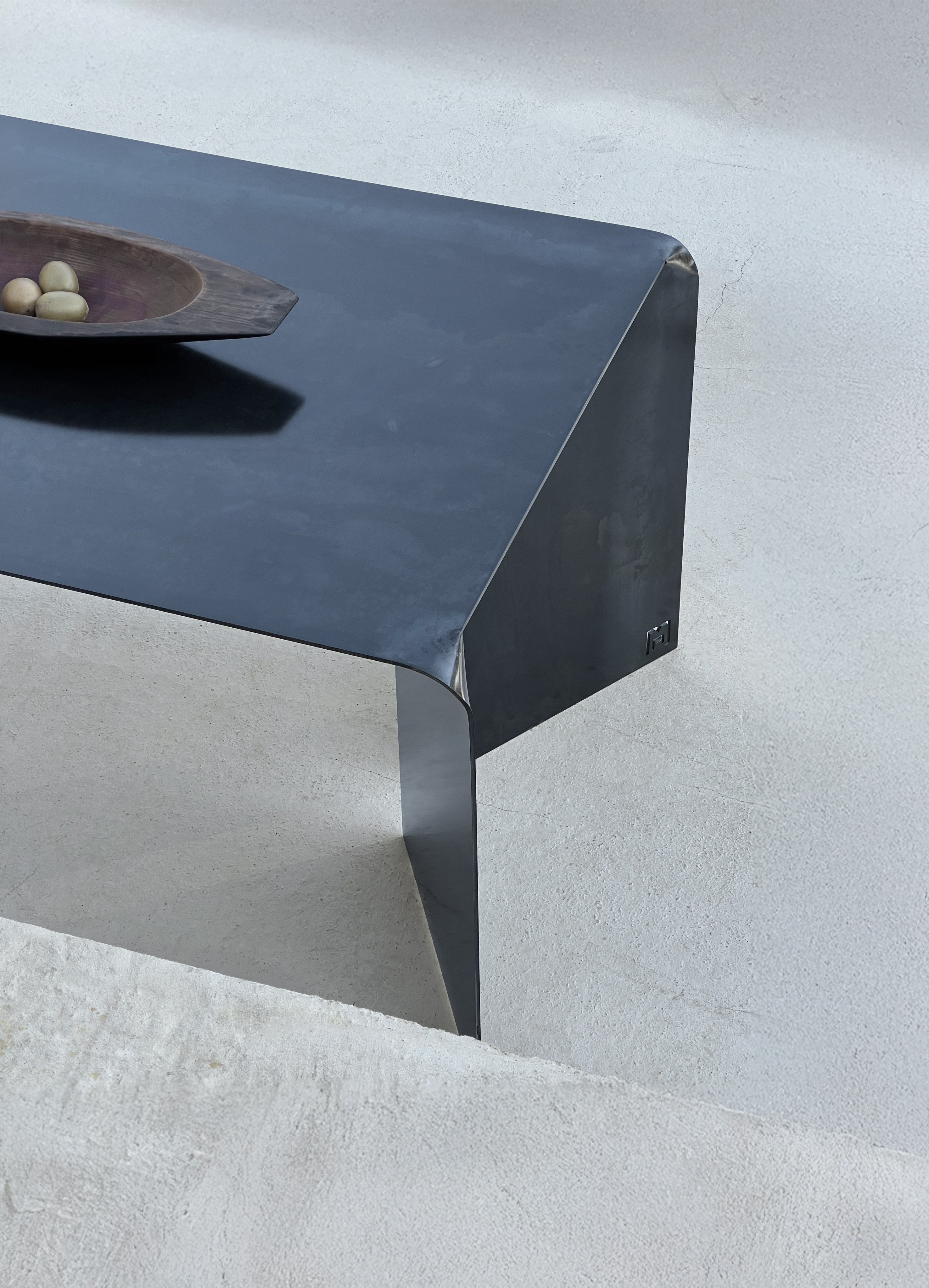 Doa' Steel Desk — angled view on textured concrete surface