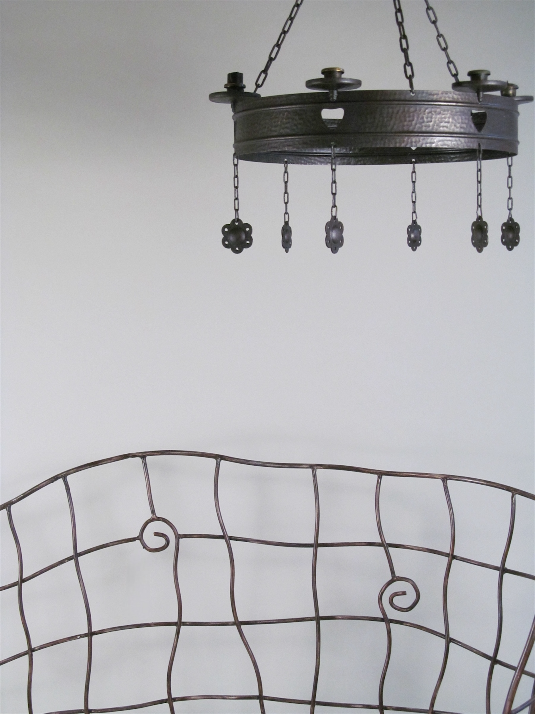 Art Nouveau Wrought-Iron Chandelier Early 20th century — overhead view above wrought-iron bench