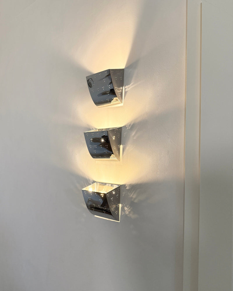 Jolene Wall Lamp - Polished Steel — close-up of polished steel surface with light reflections