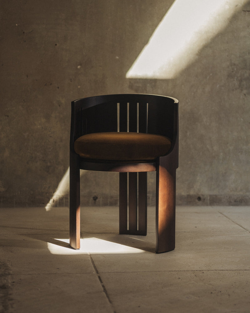 La Chaise 01 — close-up of dark wood frame with brown cushion