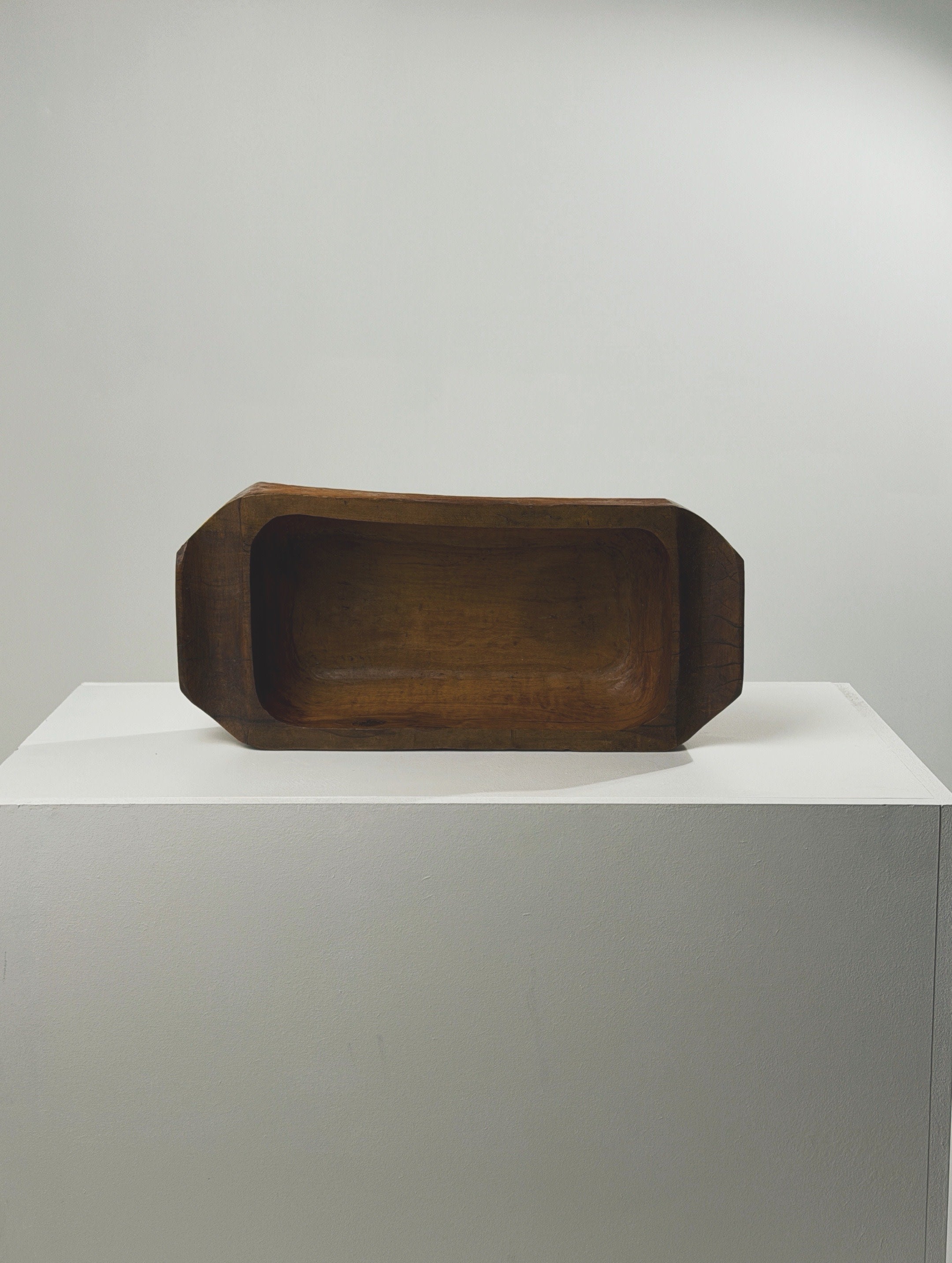Large hand-carved wooden bowl, France, early 20th century — side angle on white pedestal
