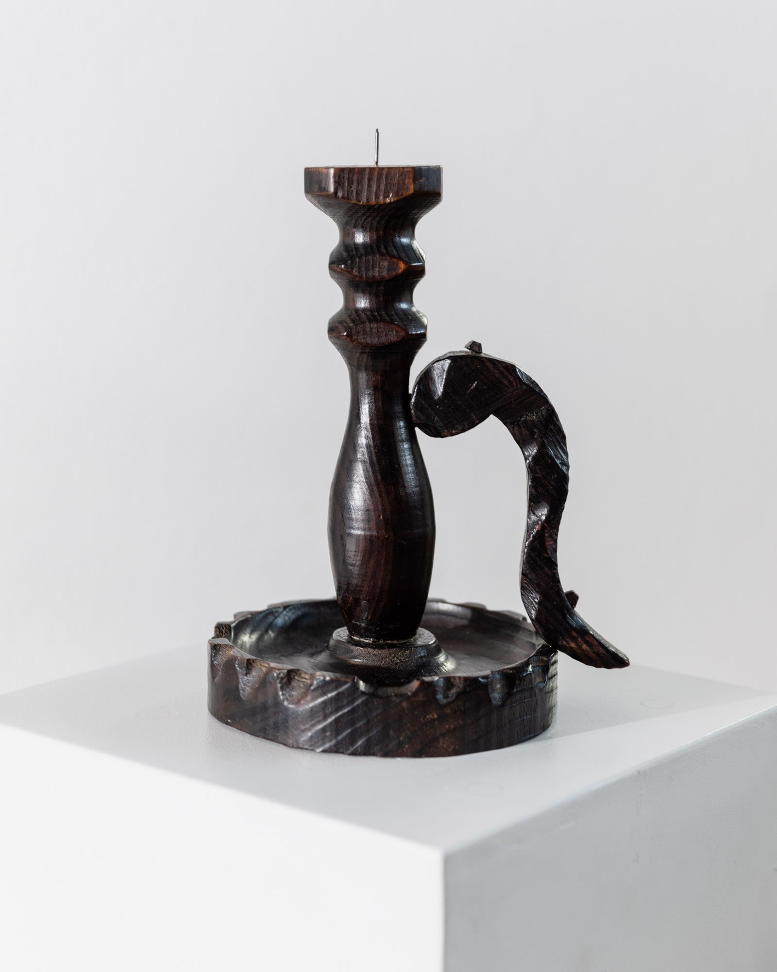 The 1960s Wooden Candleholder by Bottega Jacobs features handcarved dark wood and a sculpted fish design on a round, textured base, showcasing Brutalist style on a white pedestal against a plain background.