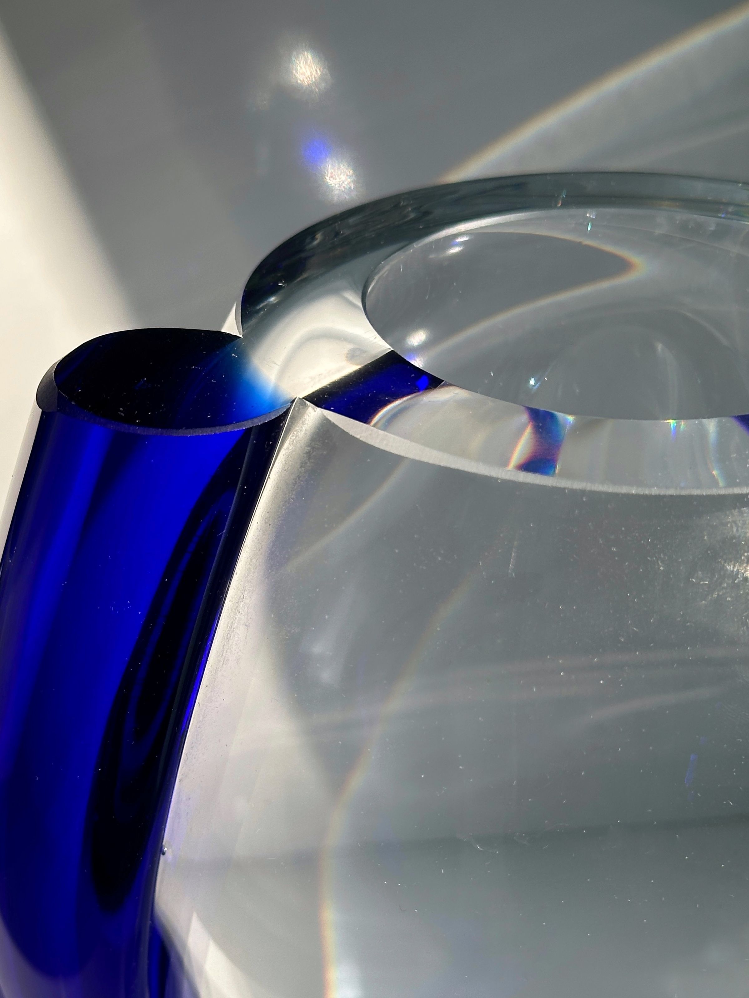Crystal glass vase detail showing curved transparent and blue forms