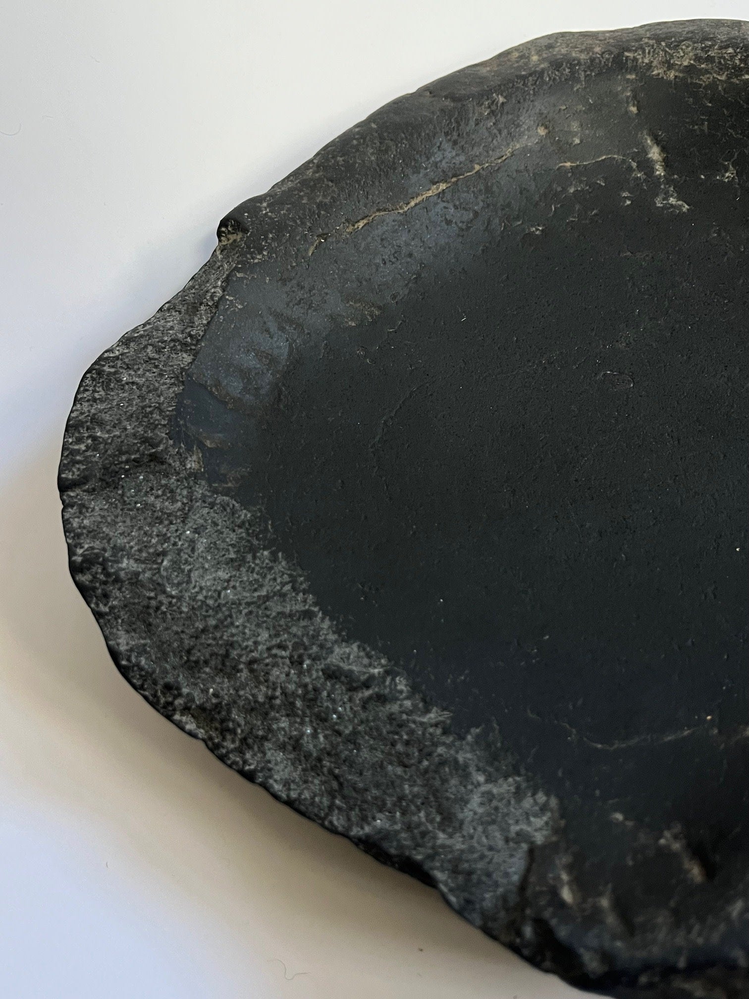 Close-up detail of antique black stone bowl textured surface