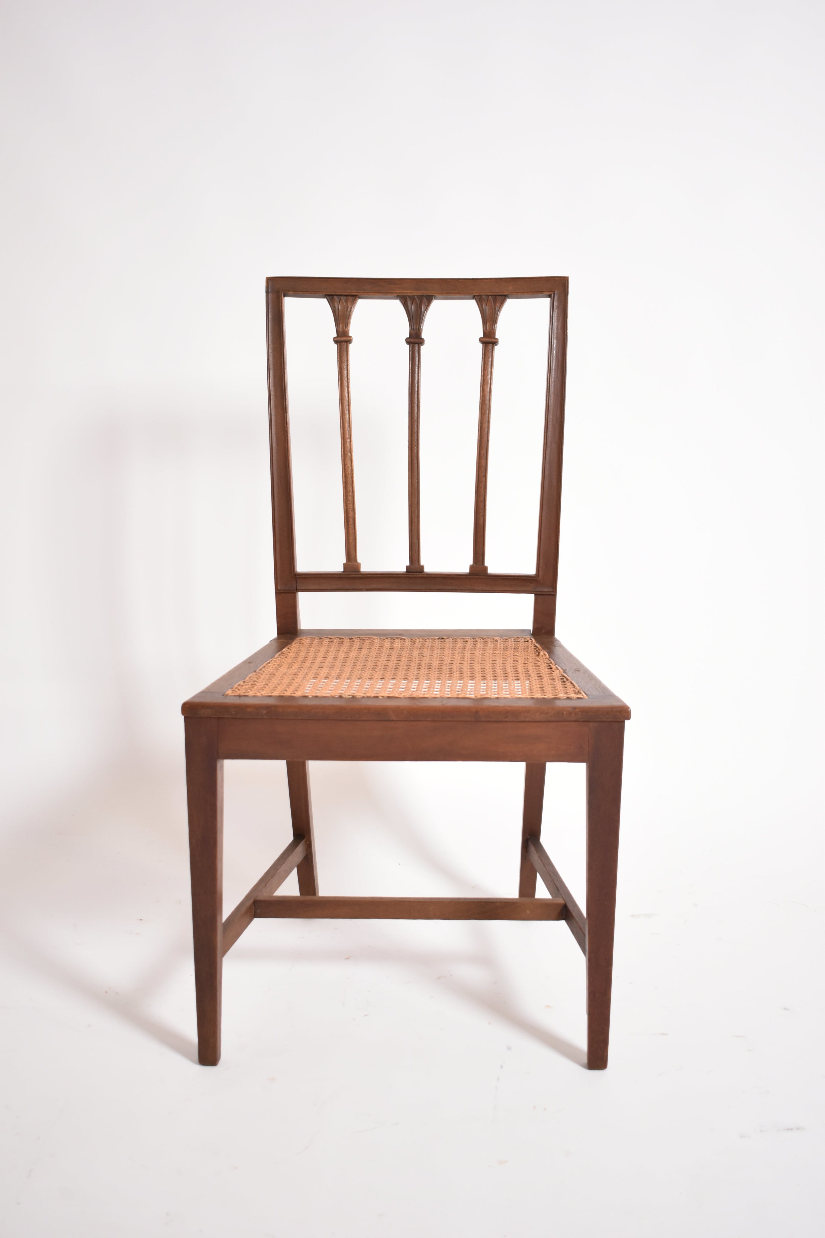 Pair of Dona Maria Chairs by Barracuda Interiors, 19th c—crafted in wood with woven cane seats, straight legs, and backrests adorned with three vertical carved slats and decorative detailing. Photographed on a plain white background.