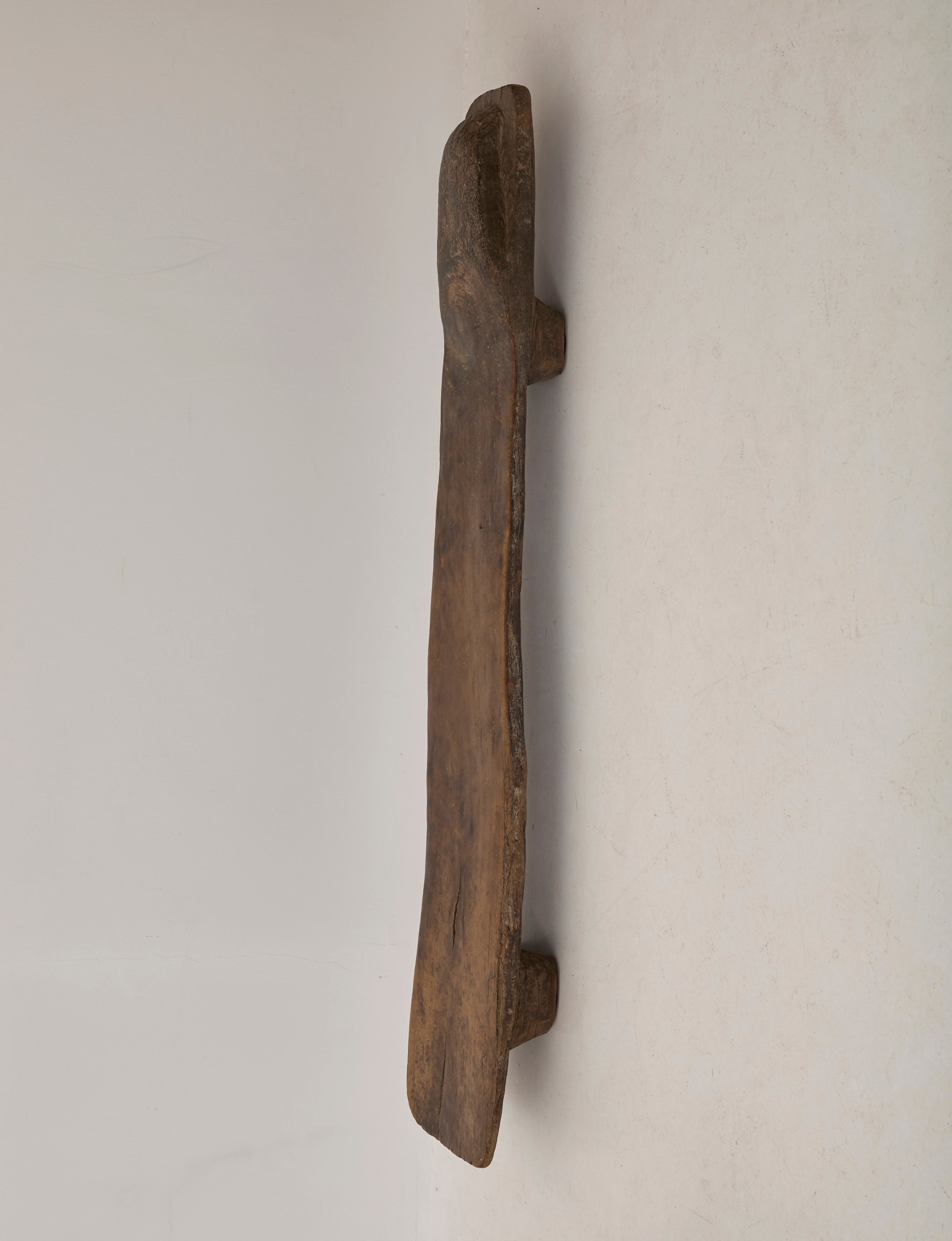 Carved Senufo Bench in Wood — side view of textured wooden seat