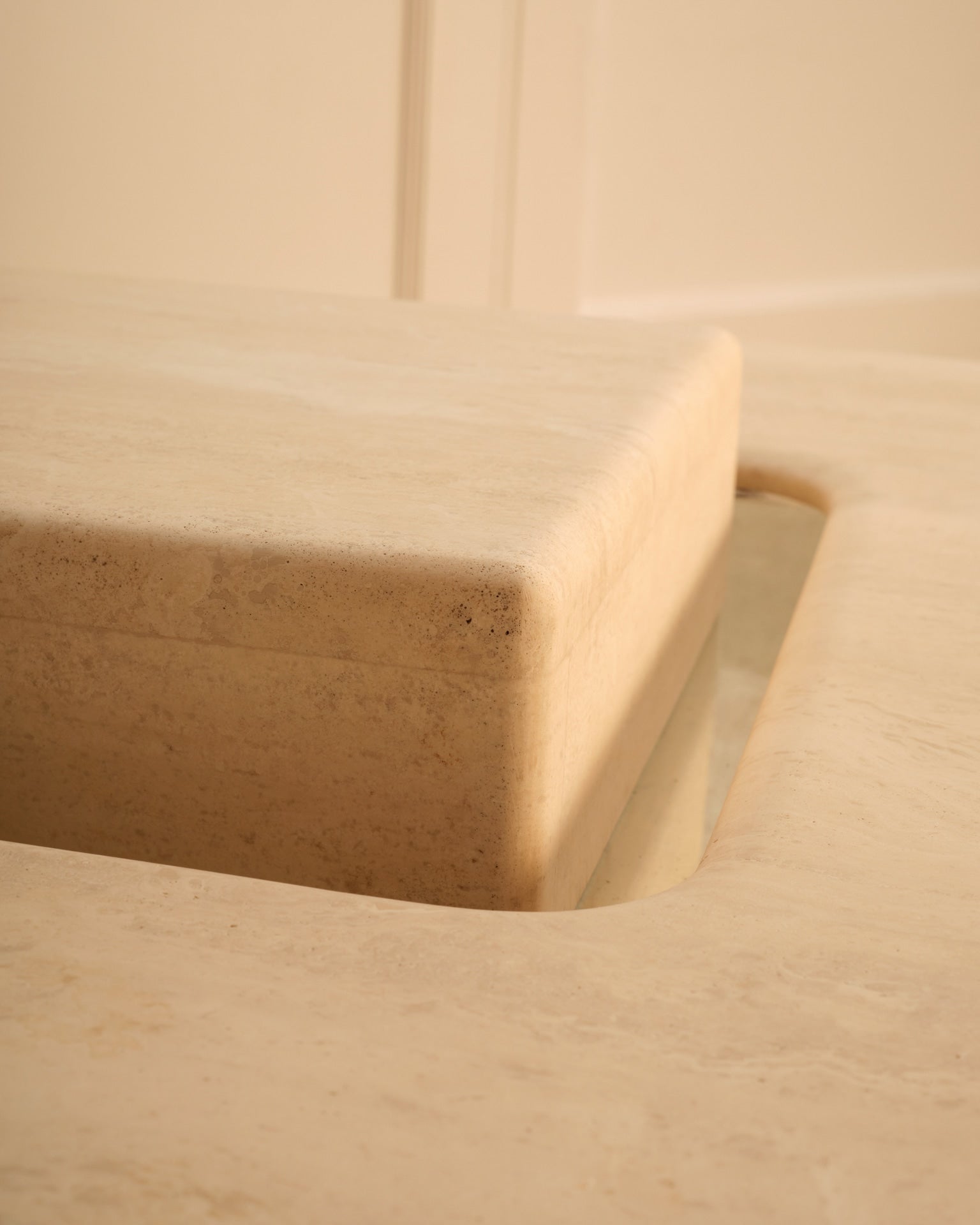 Detail view of Saturn travertine coffee table curved edge