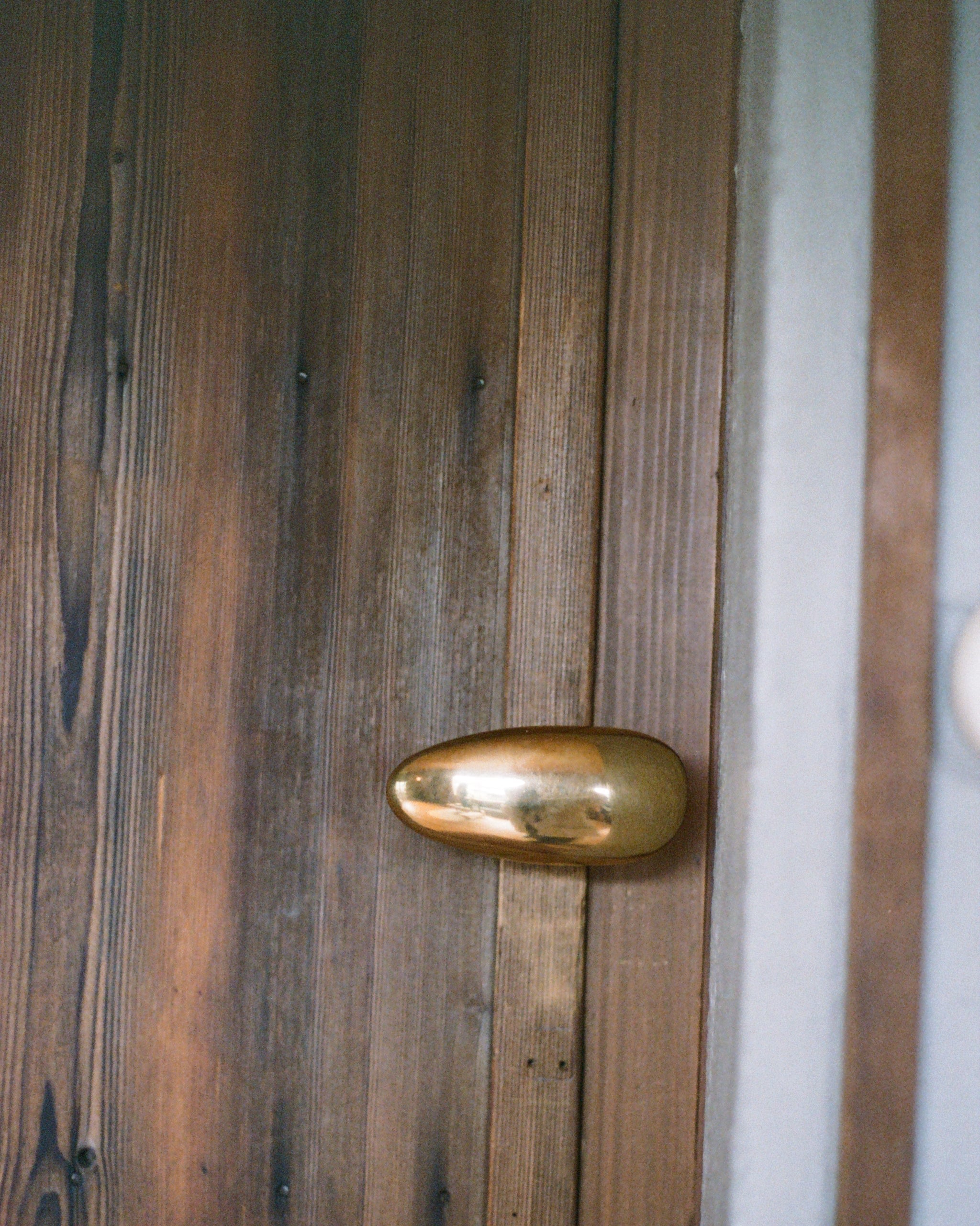 MOMI Knob/Hook Long — back view on wooden door