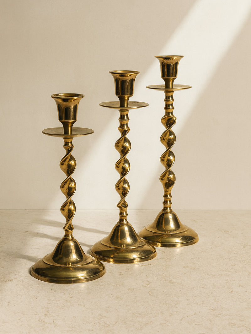 Three polished brass candlesticks with twisted spiral stems