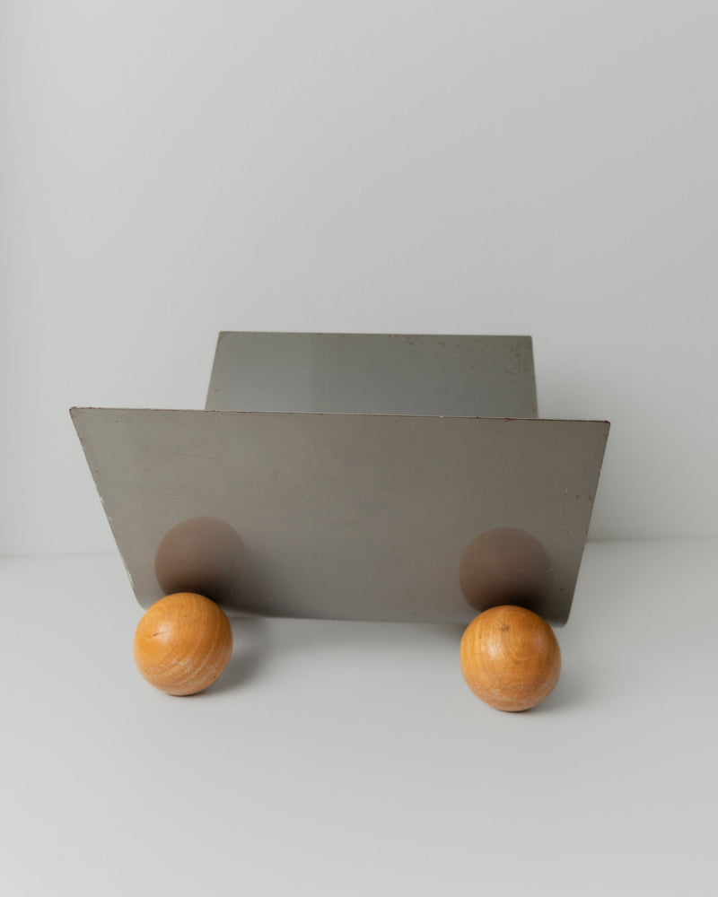 Vintage Metal Magazine Rack — close-up of gray metal base with wooden legs