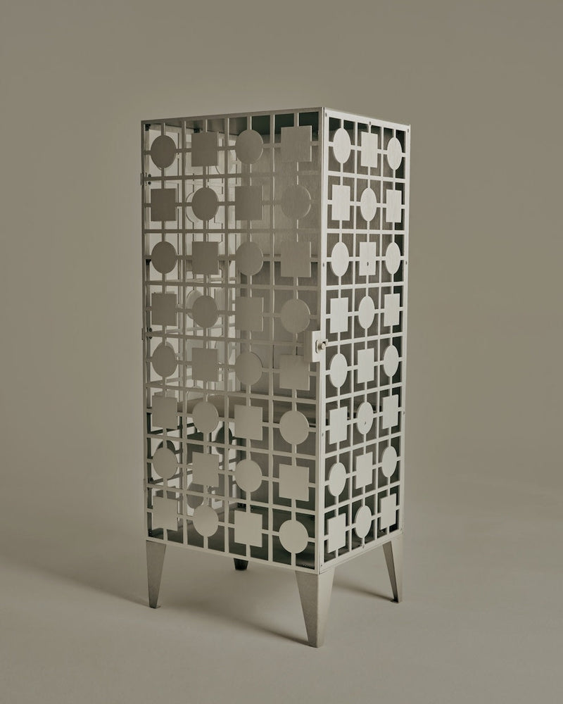 White perforated metal cabinet with geometric pattern on tapered legs