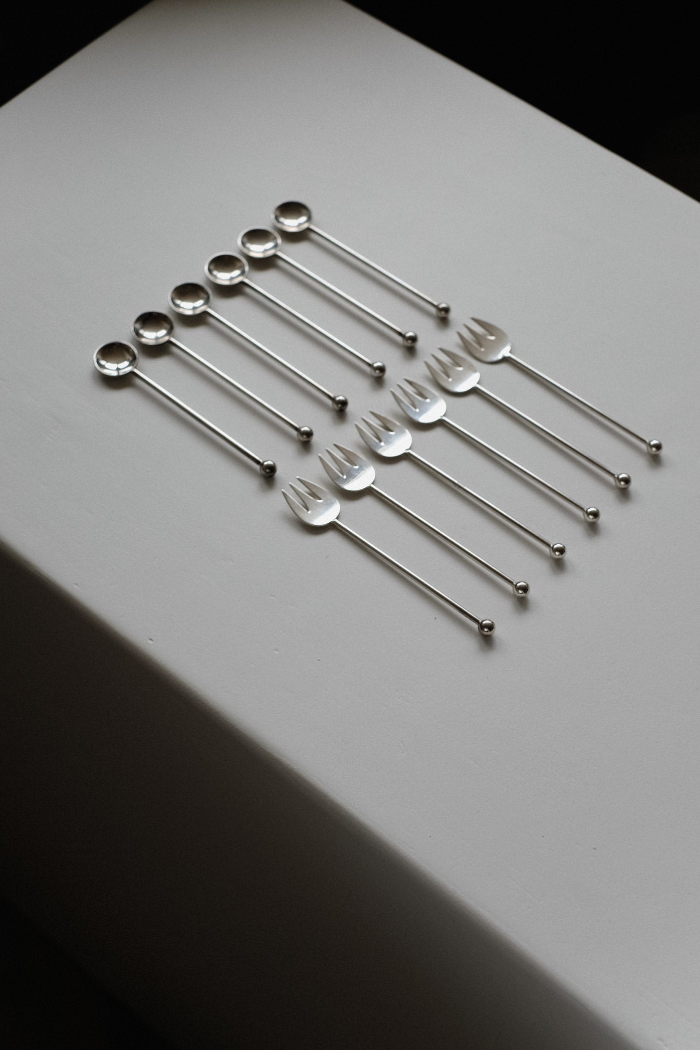 Silver-Plated Cutlery Set — top view of arranged utensils on white surface