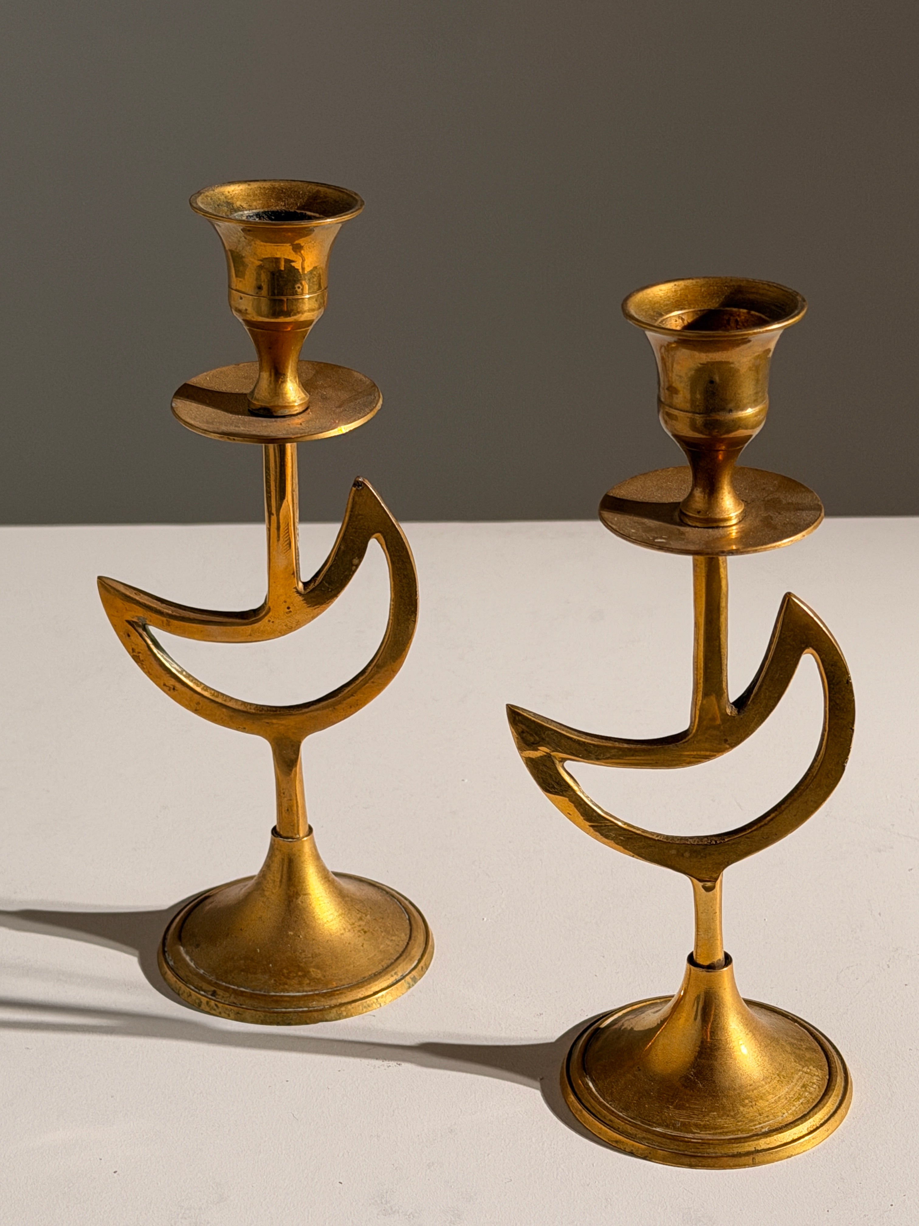 Pair of brass candlesticks with a crescent-moon motif, France, circa 1970 by Figuresdesign | The Oblist