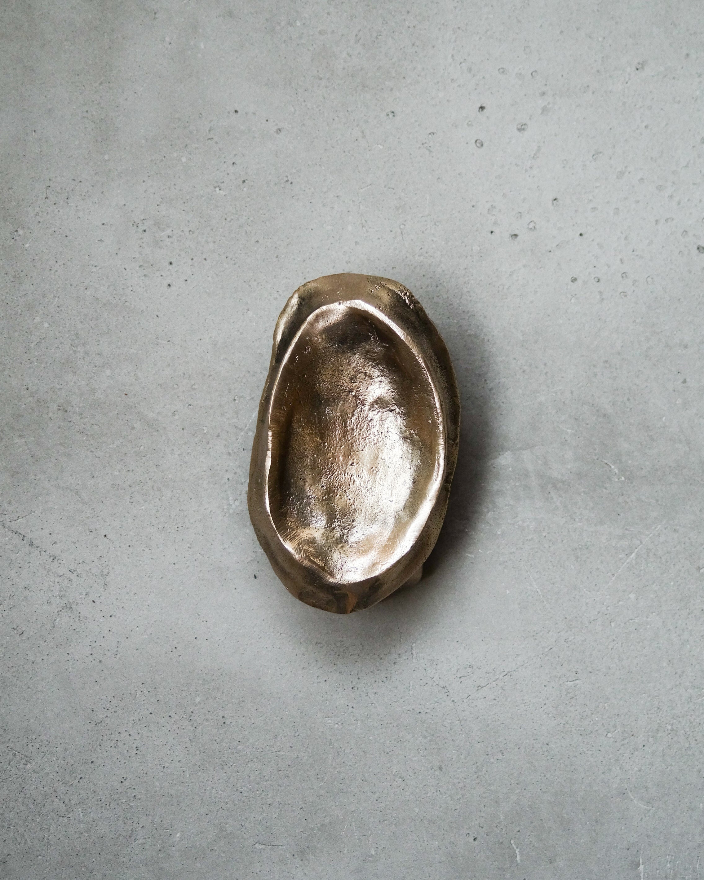 MOORE Tray/Catchall — top view of textured brass dish on concrete surface