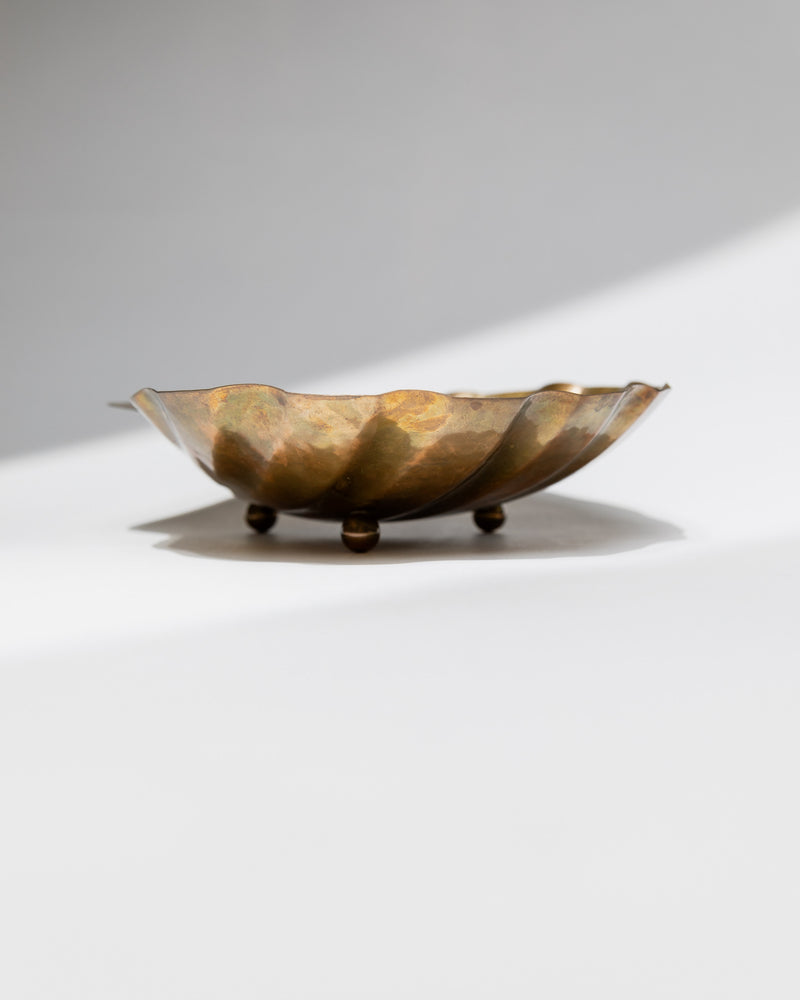 Brass bowl profile view showing patinated finish and elegant feet