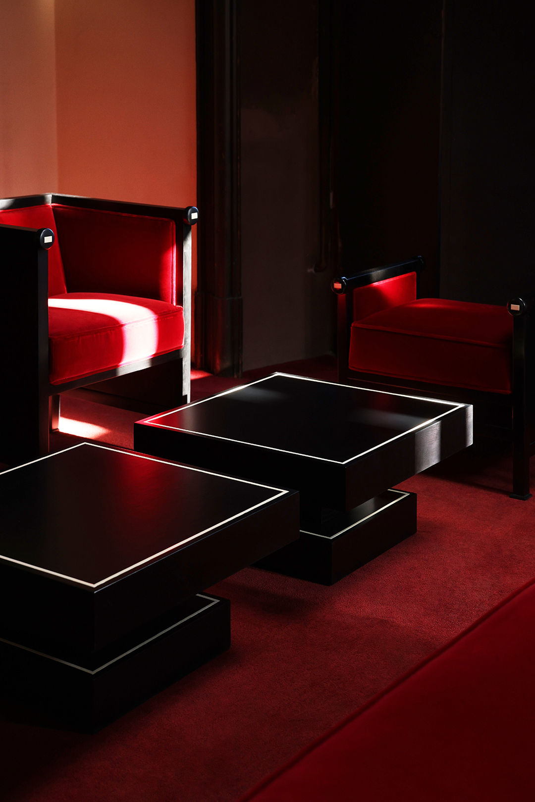 Keys Armchair — side angle with red velvet upholstery and black accents