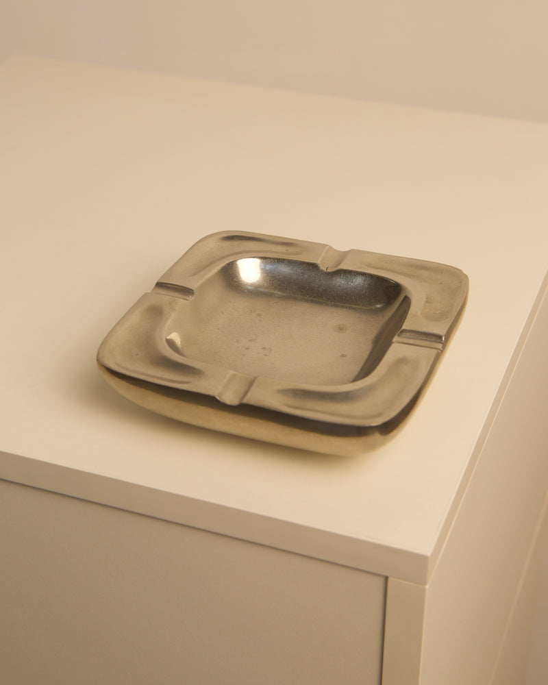 Vintage square aluminum ashtray from the 1970s on white surface