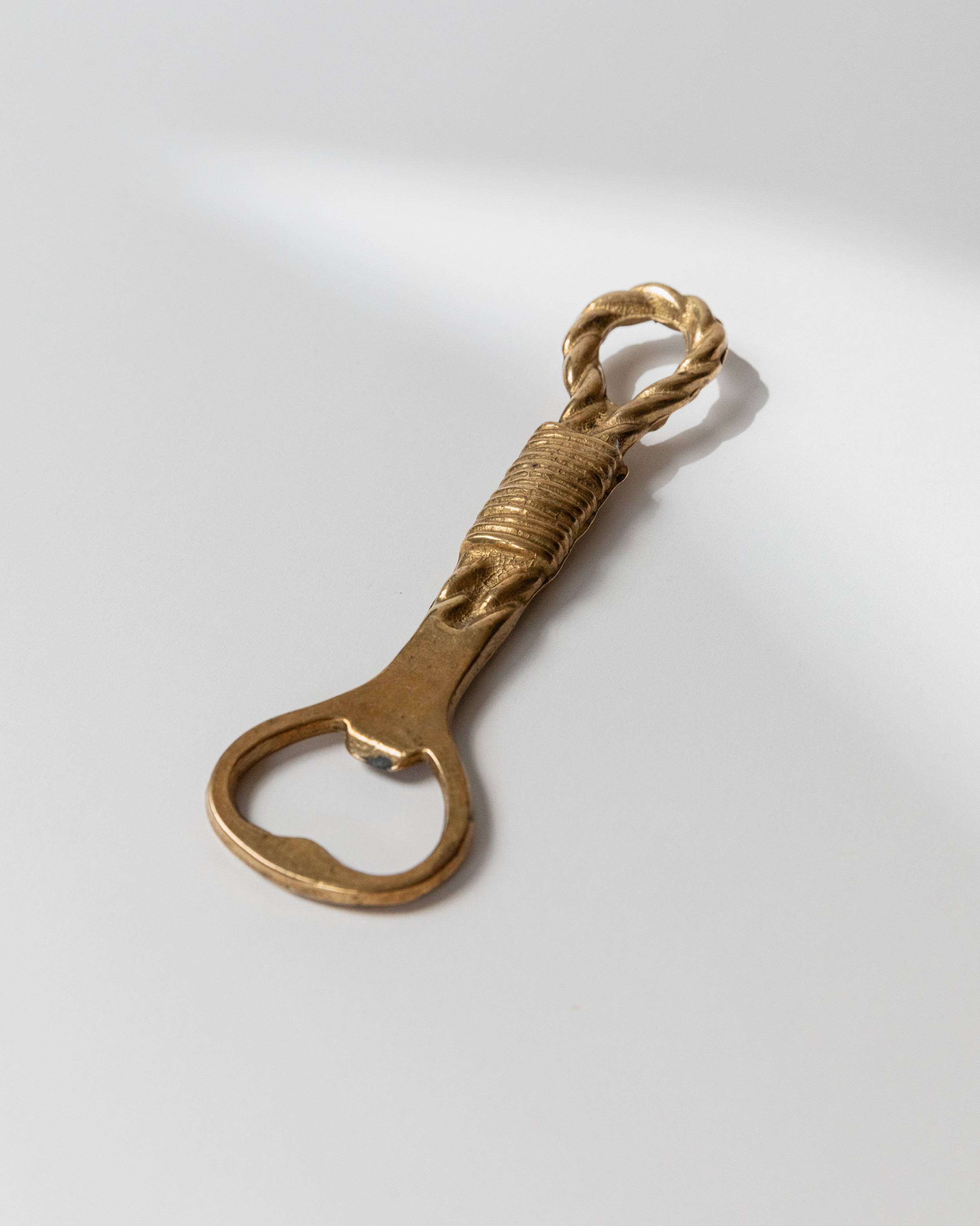 Vintage brass bottle opener with twisted rope handle detail