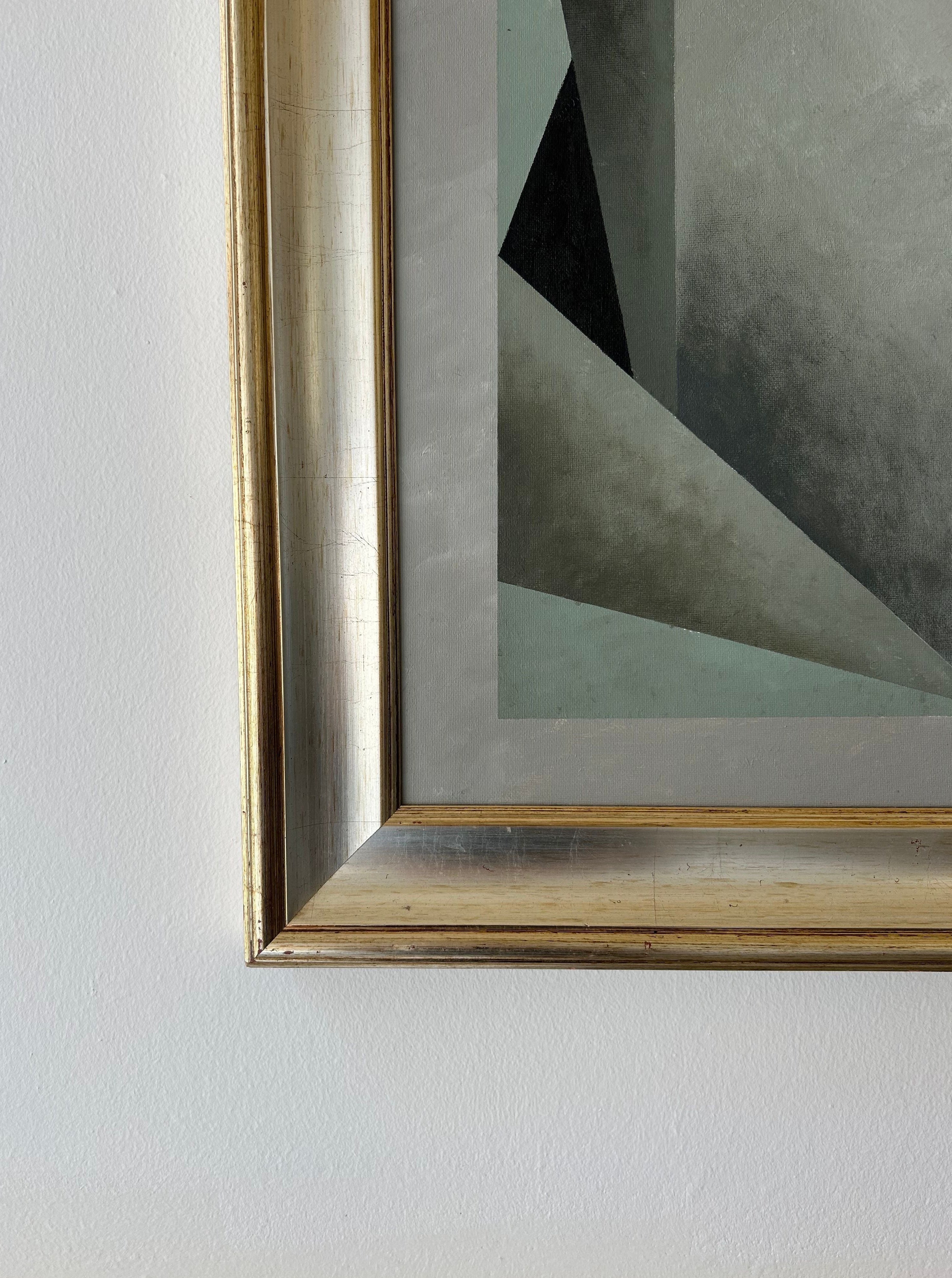 Close-up of the bottom left corner of Iris Bavelaar's "Nest" painting, featuring gray and black geometric shapes on linen. The metallic gold-finished frame adds a contemporary classic touch to this wall art against a white wall.