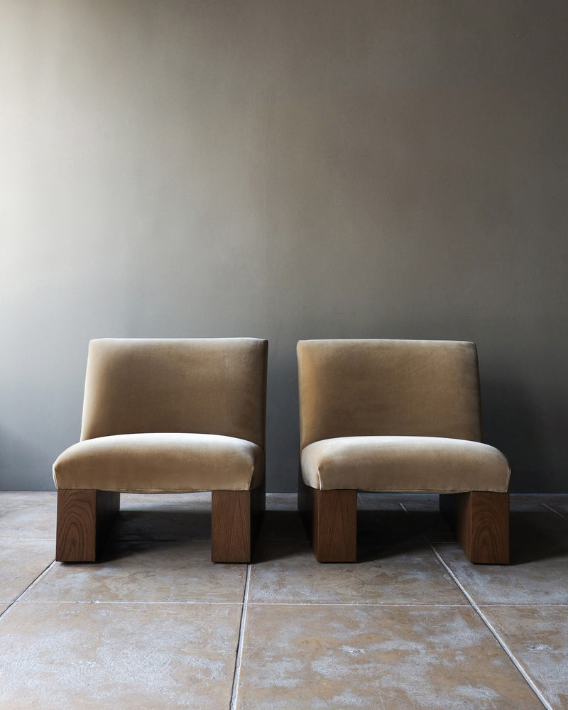 Two beige upholstered Doheny lounge chairs with walnut legs