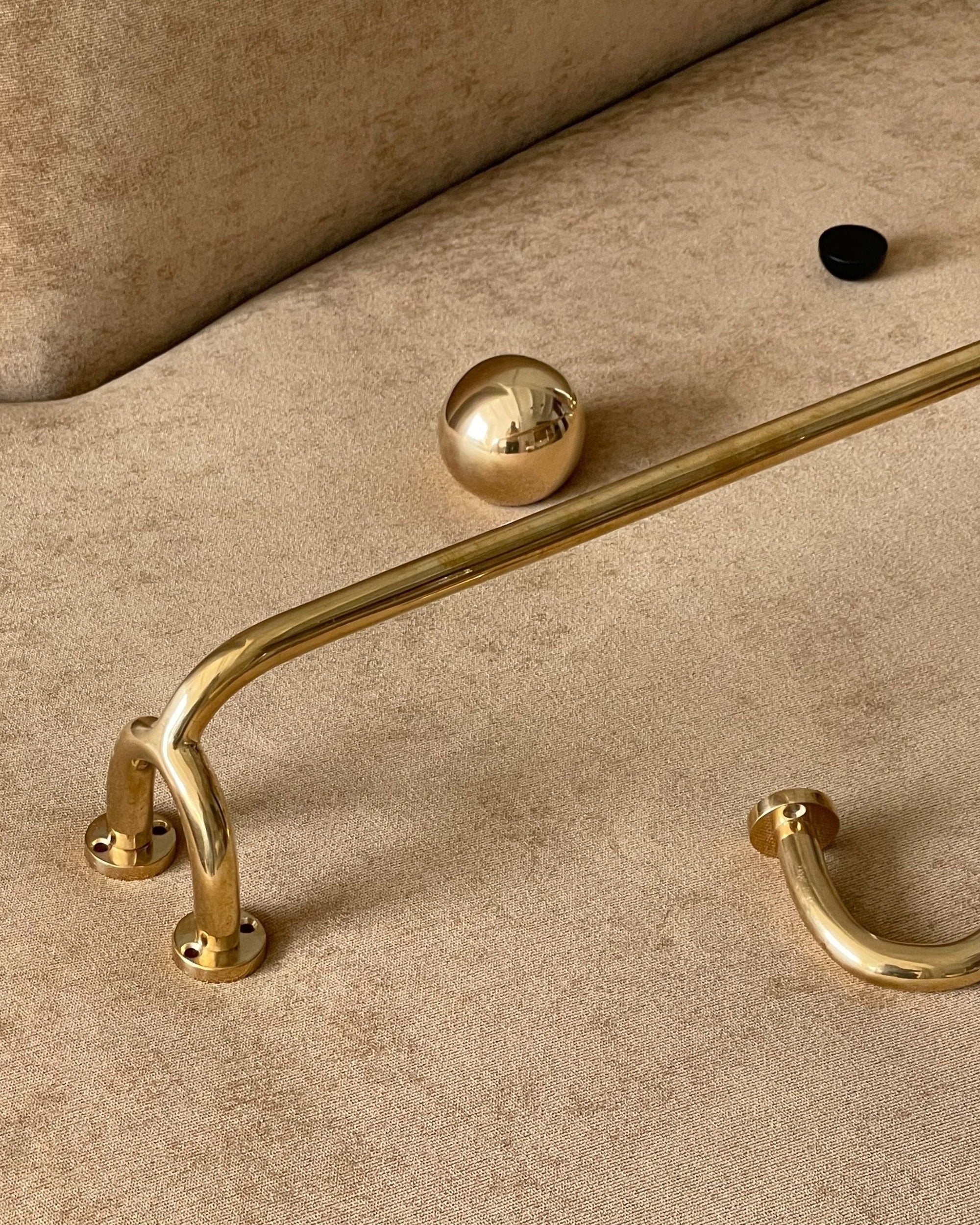 CERCLE Cabinet Knob Large — brass knob on beige upholstered surface