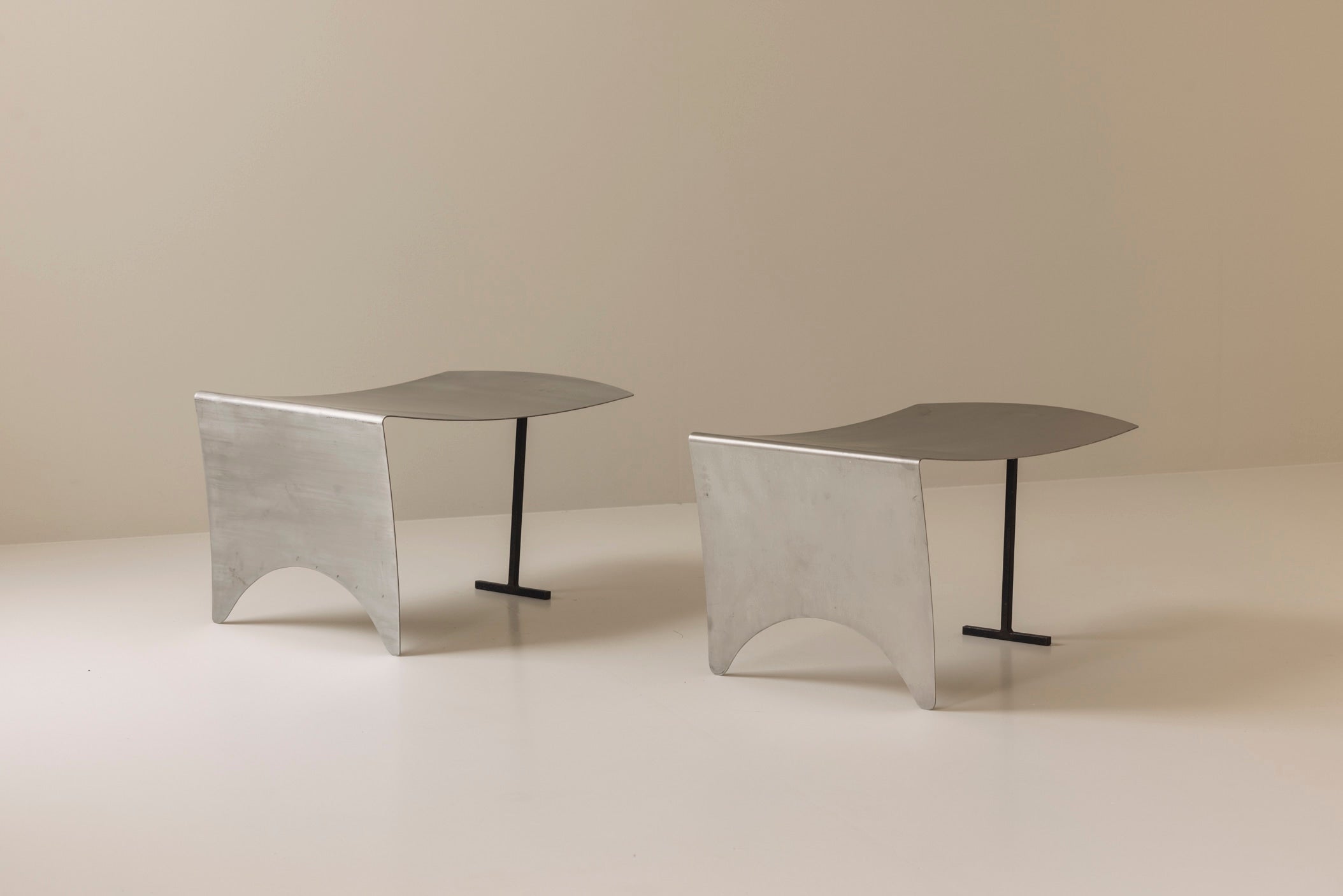 A striking set Modernist curved metal stools from France, dating to the 1980s. — close-up