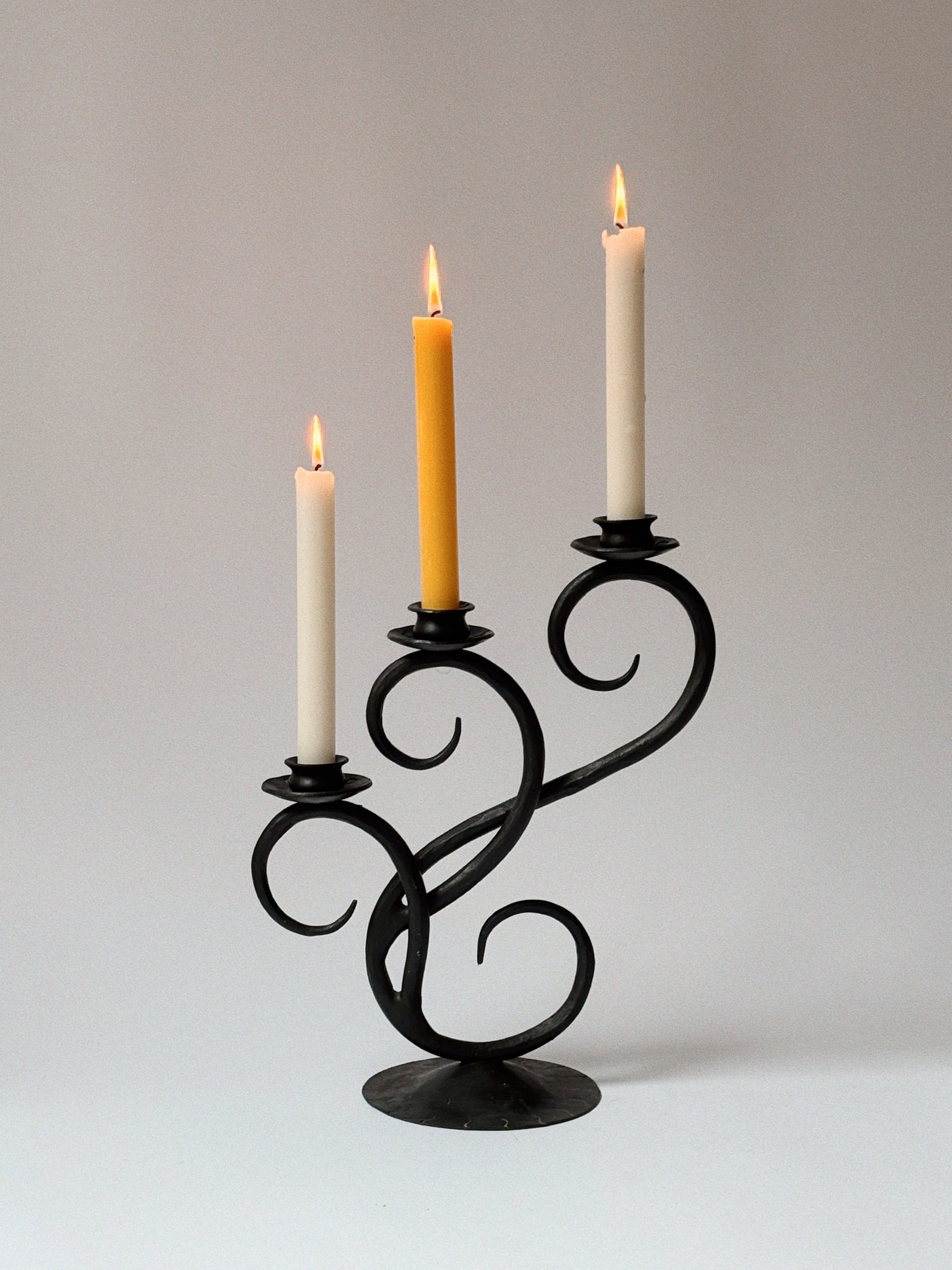 Wrought Iron 3 Arm Swirl Candelabra — close-up of black metal with candles