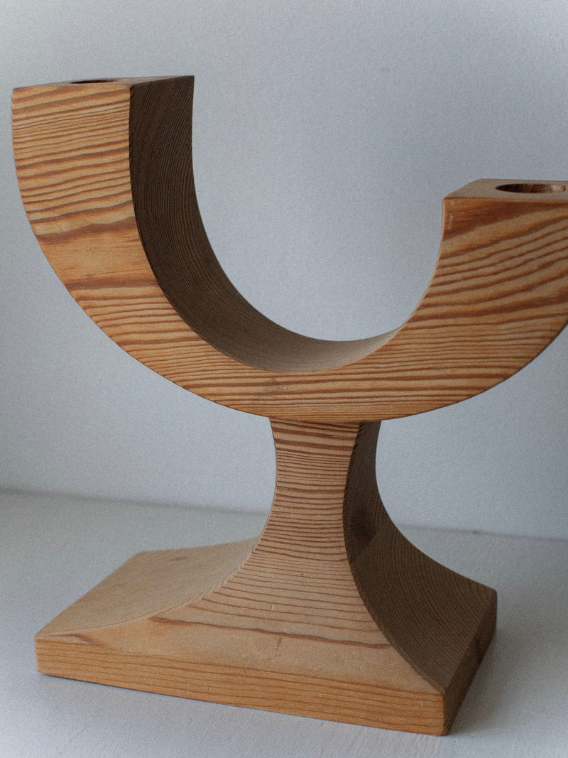 The Out For Lunch Wooden Candleholder features a modern geometric C-shaped curve and rectangular base, making this pre-loved decor a unique choice for displaying two candles against any plain light background.