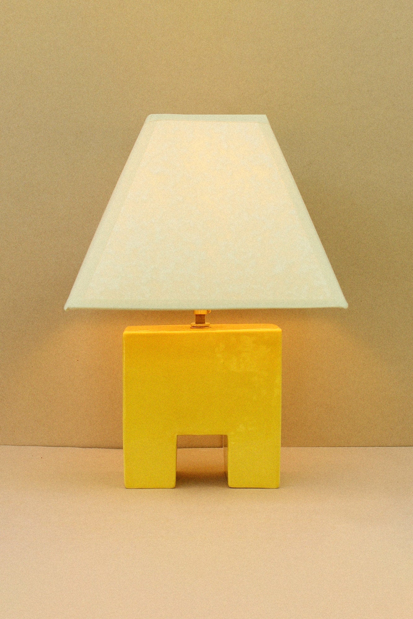 Cristo Lamp (Sol) — side angle showing yellow ceramic base
