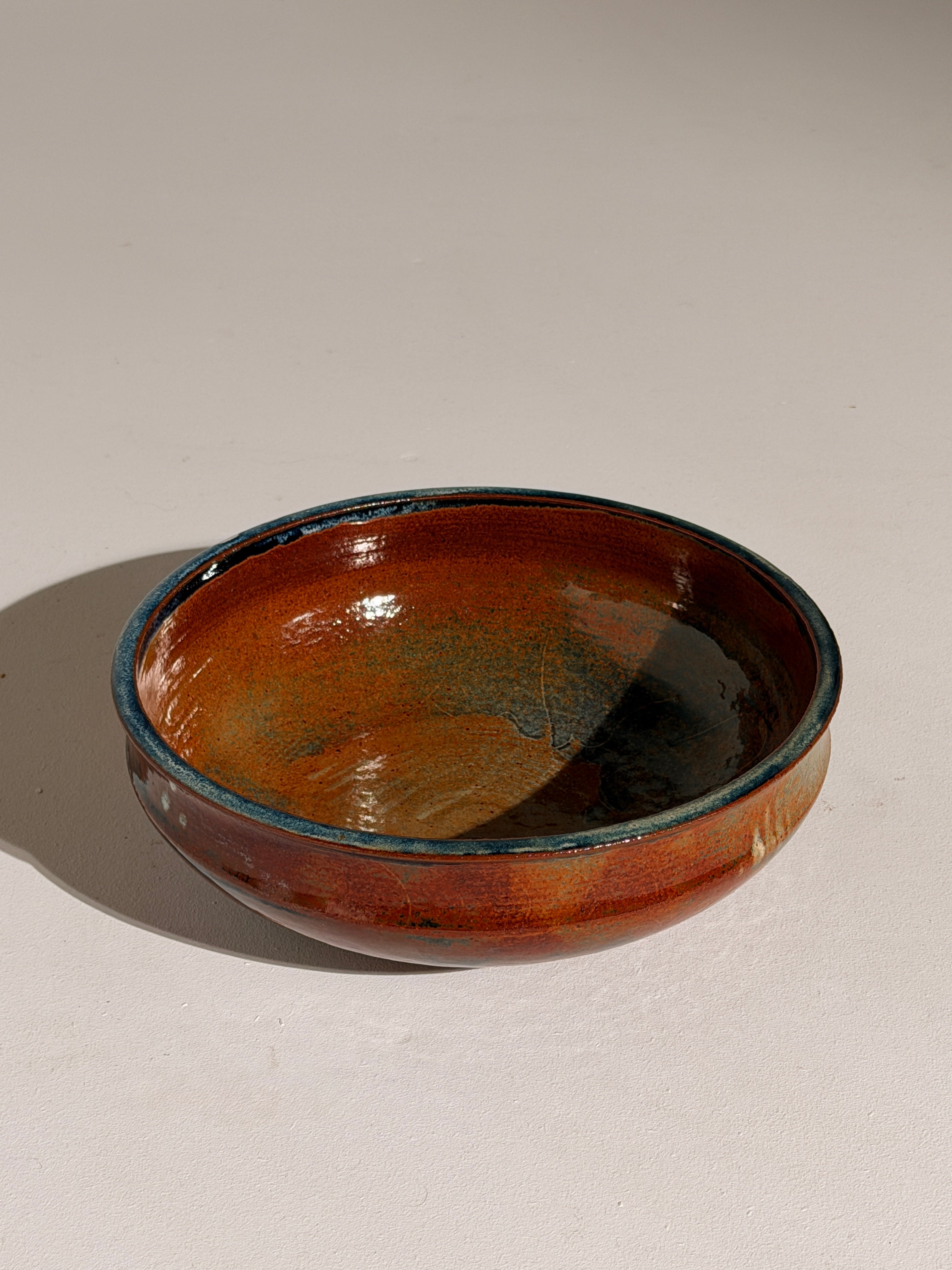 Ceramic dish by Elisabeth Wallet, circa 1960–1970 — side view highlighting rich orange glaze