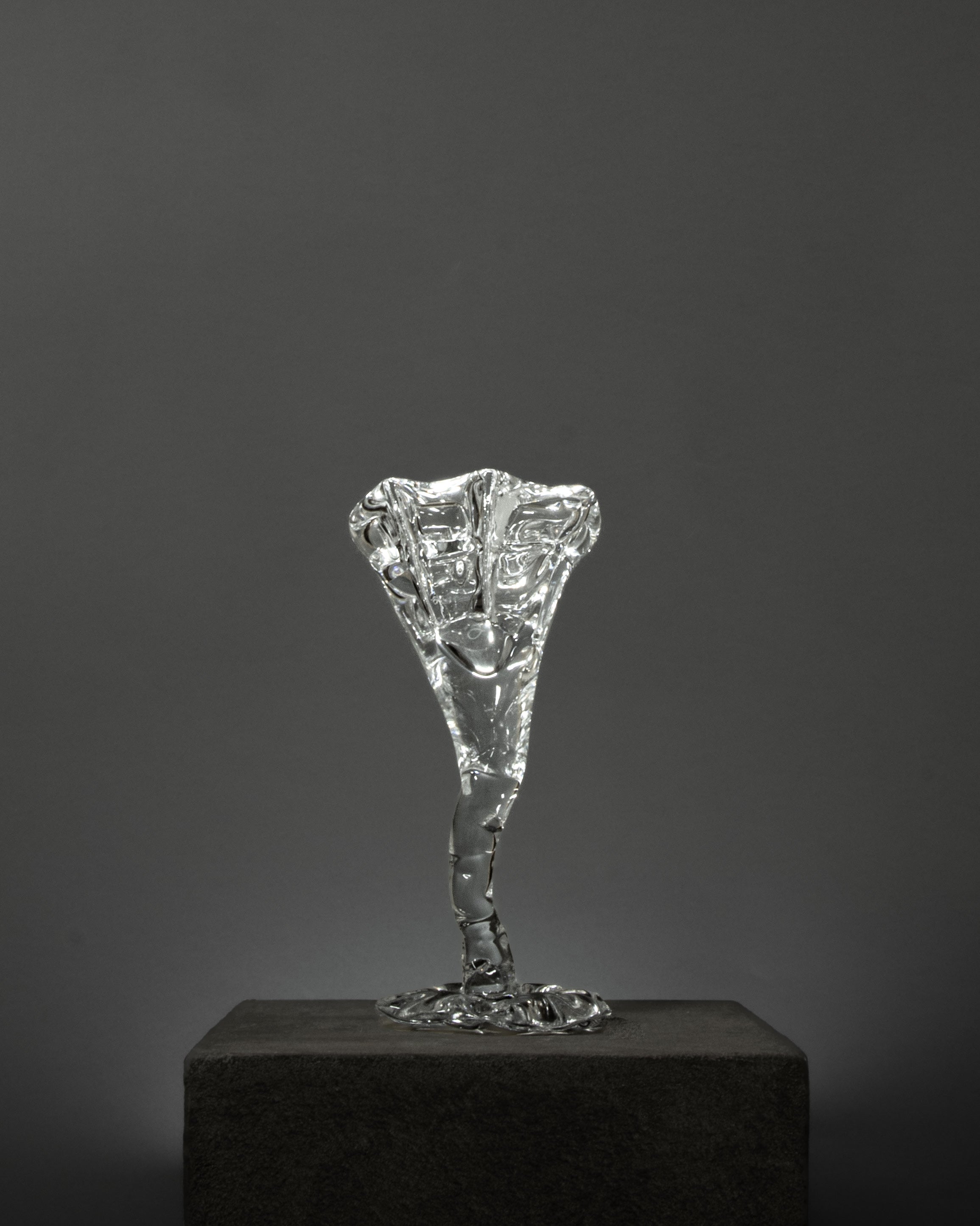 Spiky Cocktail Glass - Transparent — side angle on textured pedestal