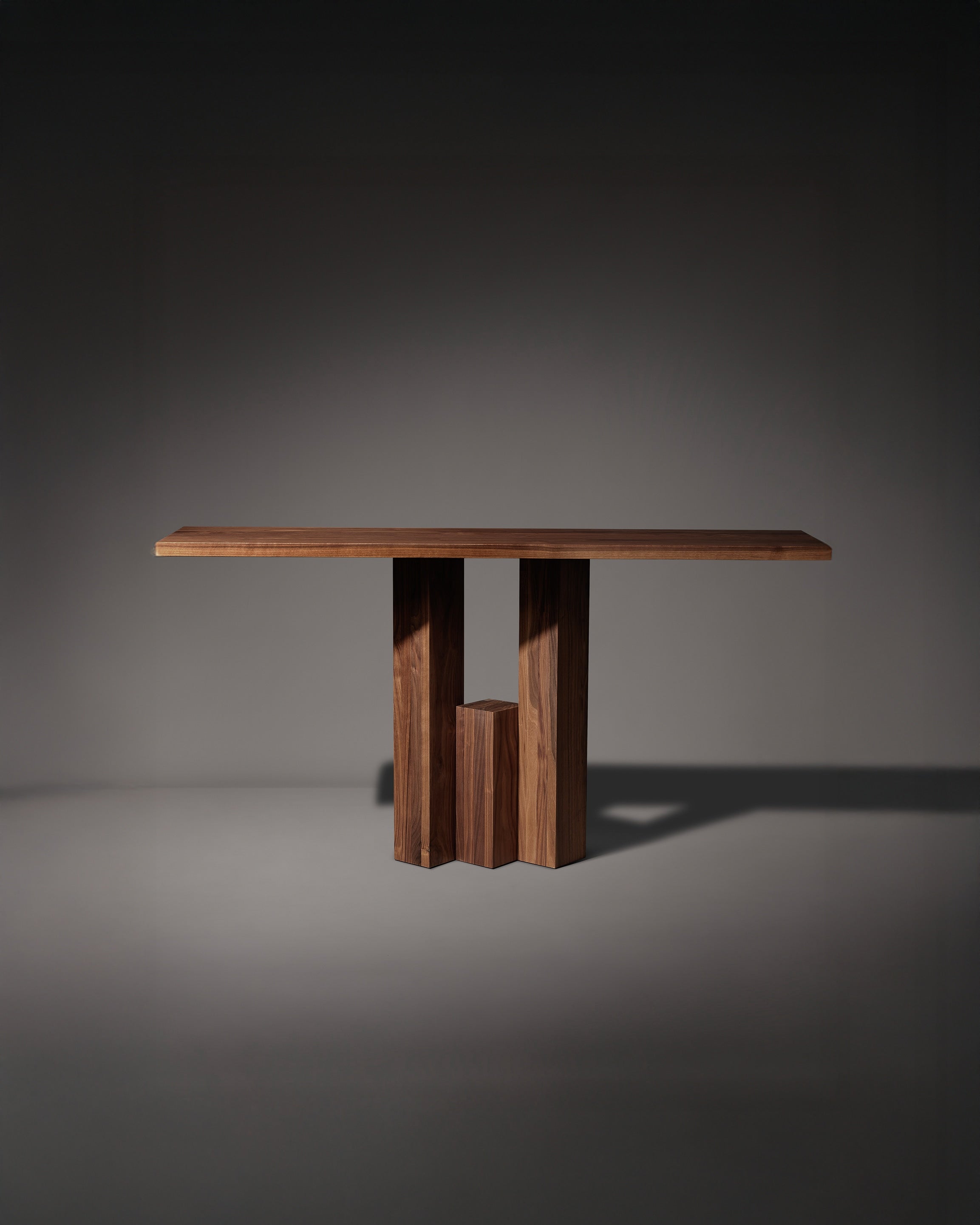 Fenestra Console — front view of walnut table with geometric base