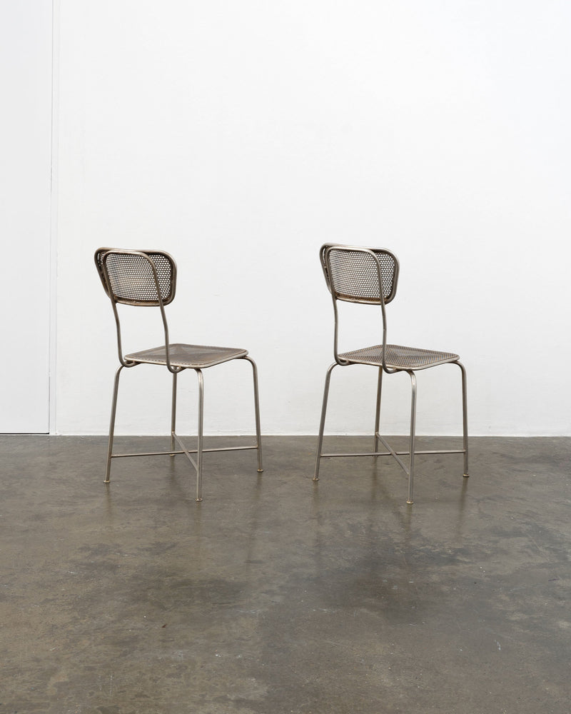 Pair of vintage perforated metal chairs with cane webbing seats