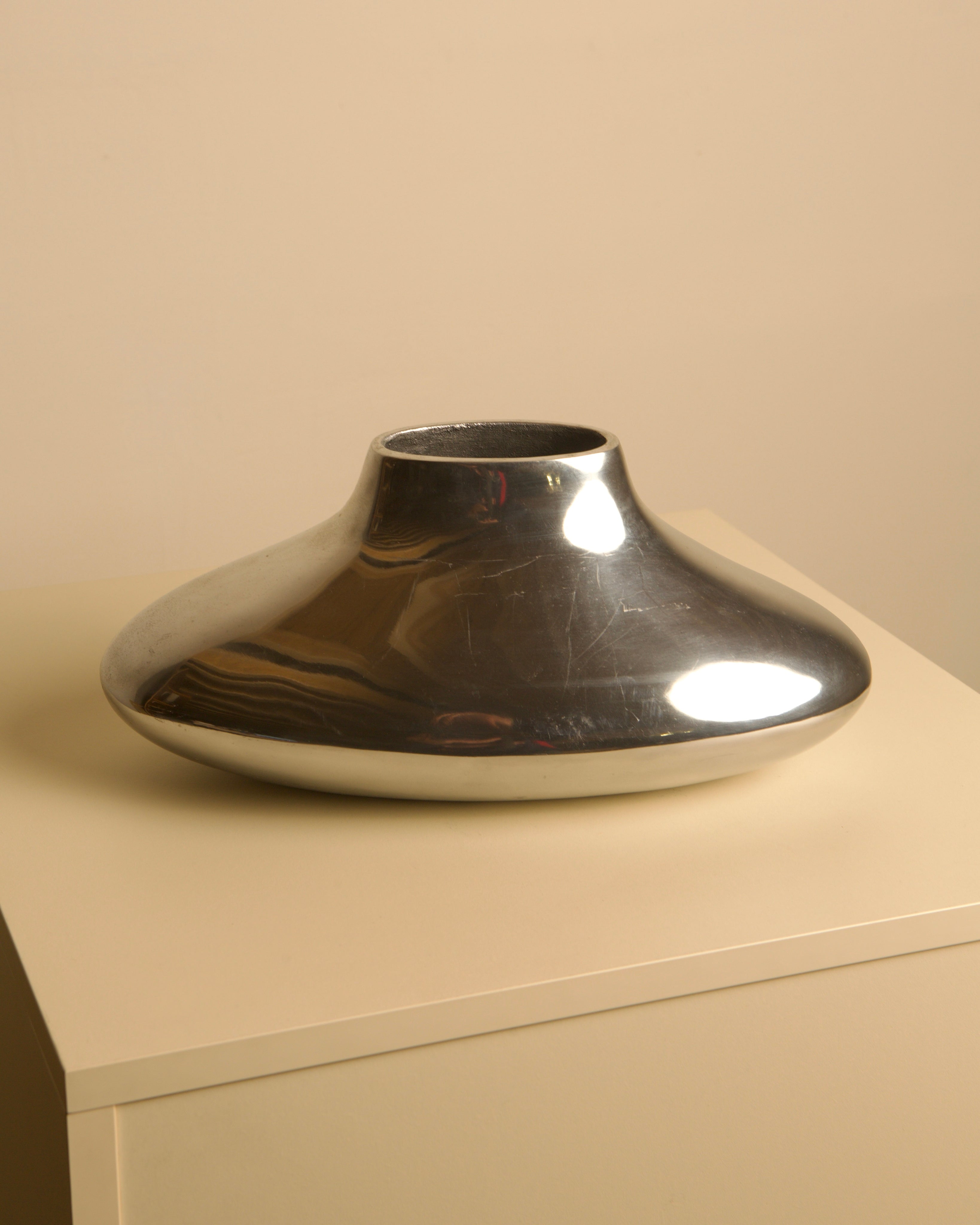 Plat Vase in Cast Aluminum 80's — close-up of polished metallic surface
